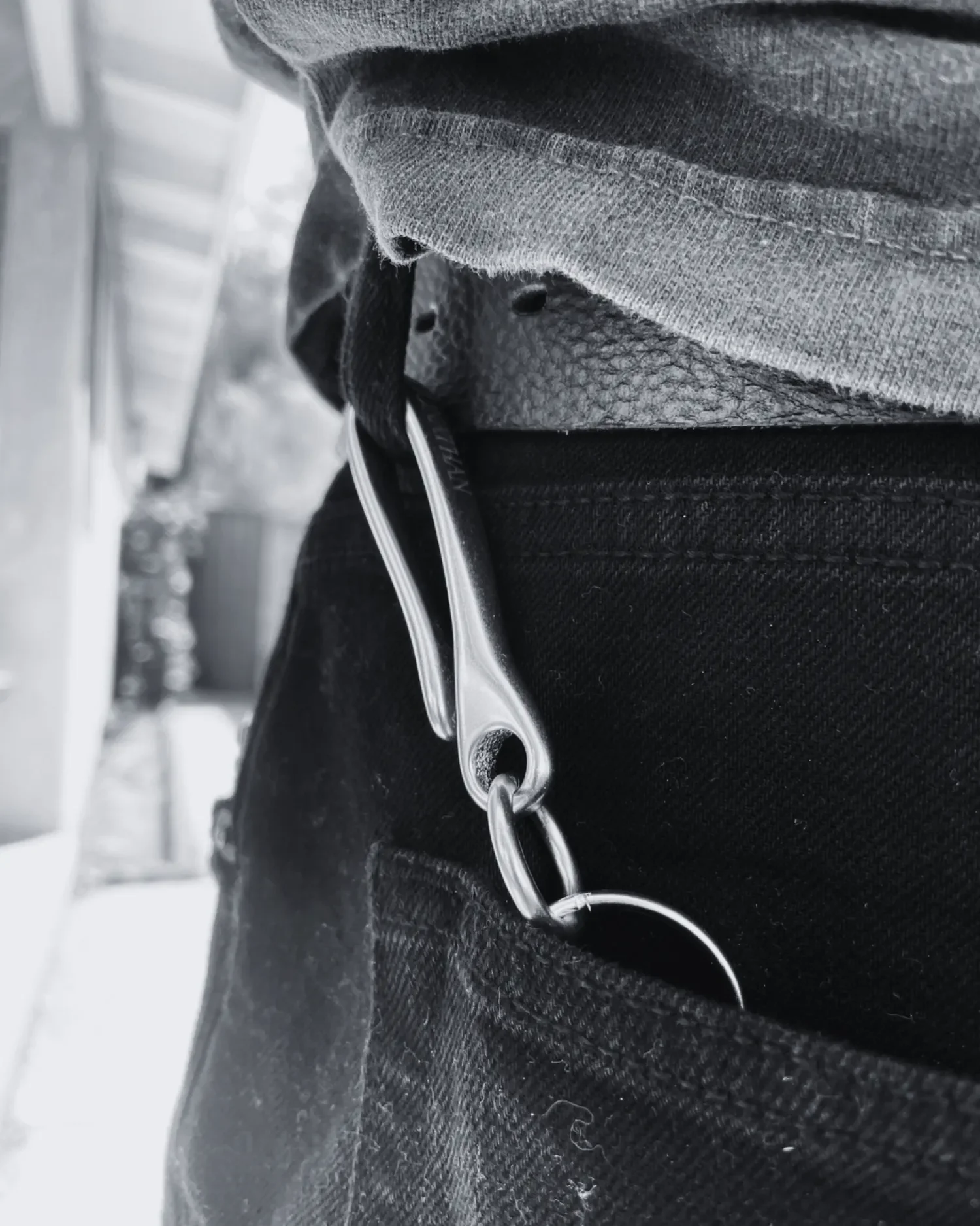 Male model wearing Engraved brass fish hook keychain with Old English name engraving, hooked onto his belt loop pocket