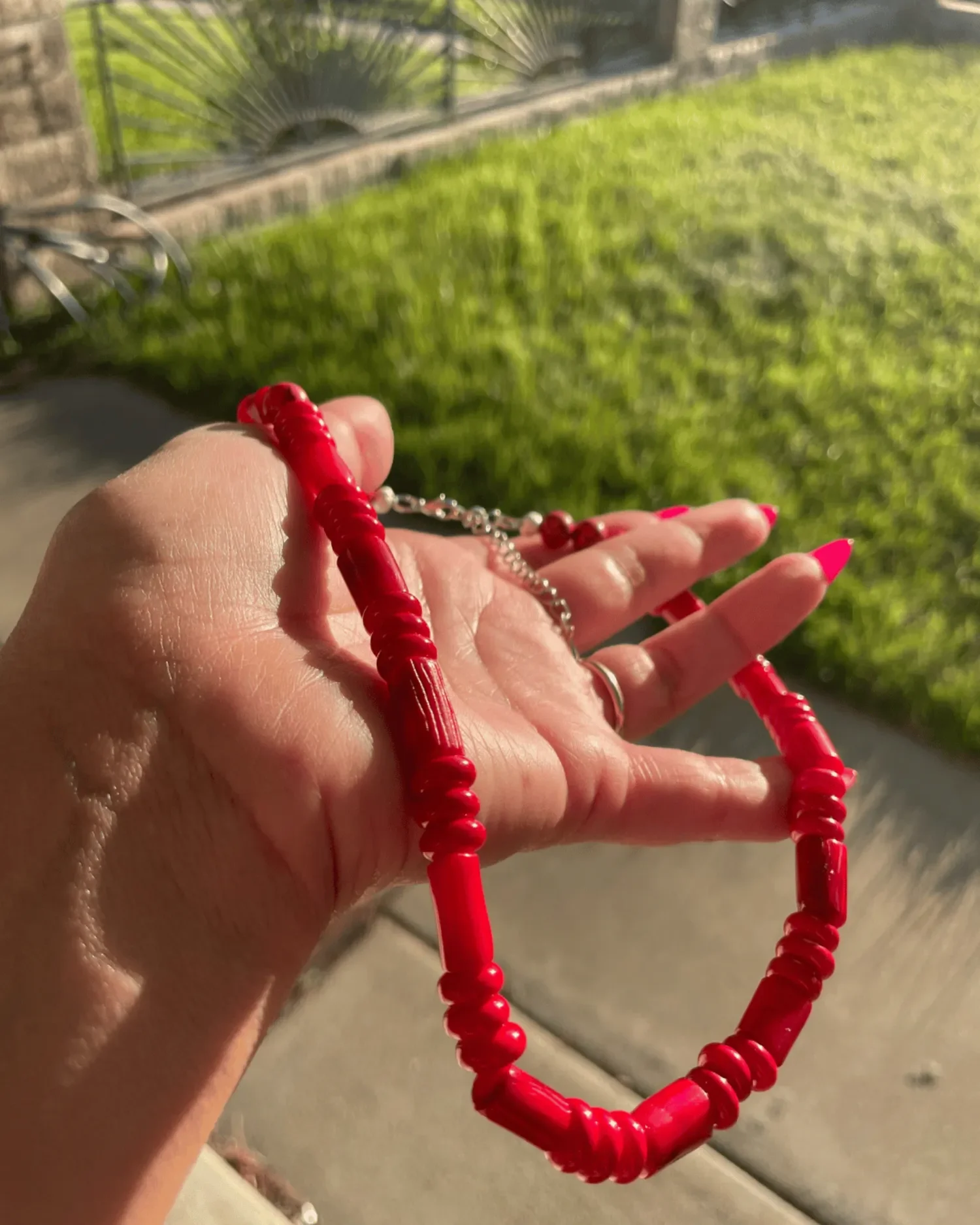 Close-up of The Scarlett Necklace, a handcrafted red beaded necklace with sterling silver hardware and lobster clasp.