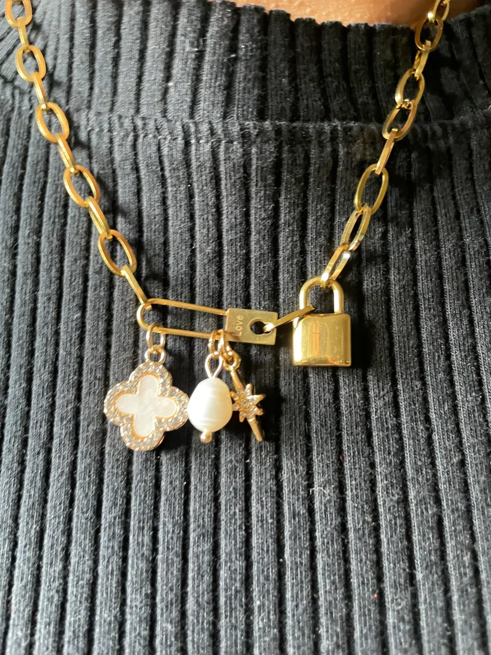 Handmade gold paperclip chain necklace with mixed charm cluster including locket and pavé clover