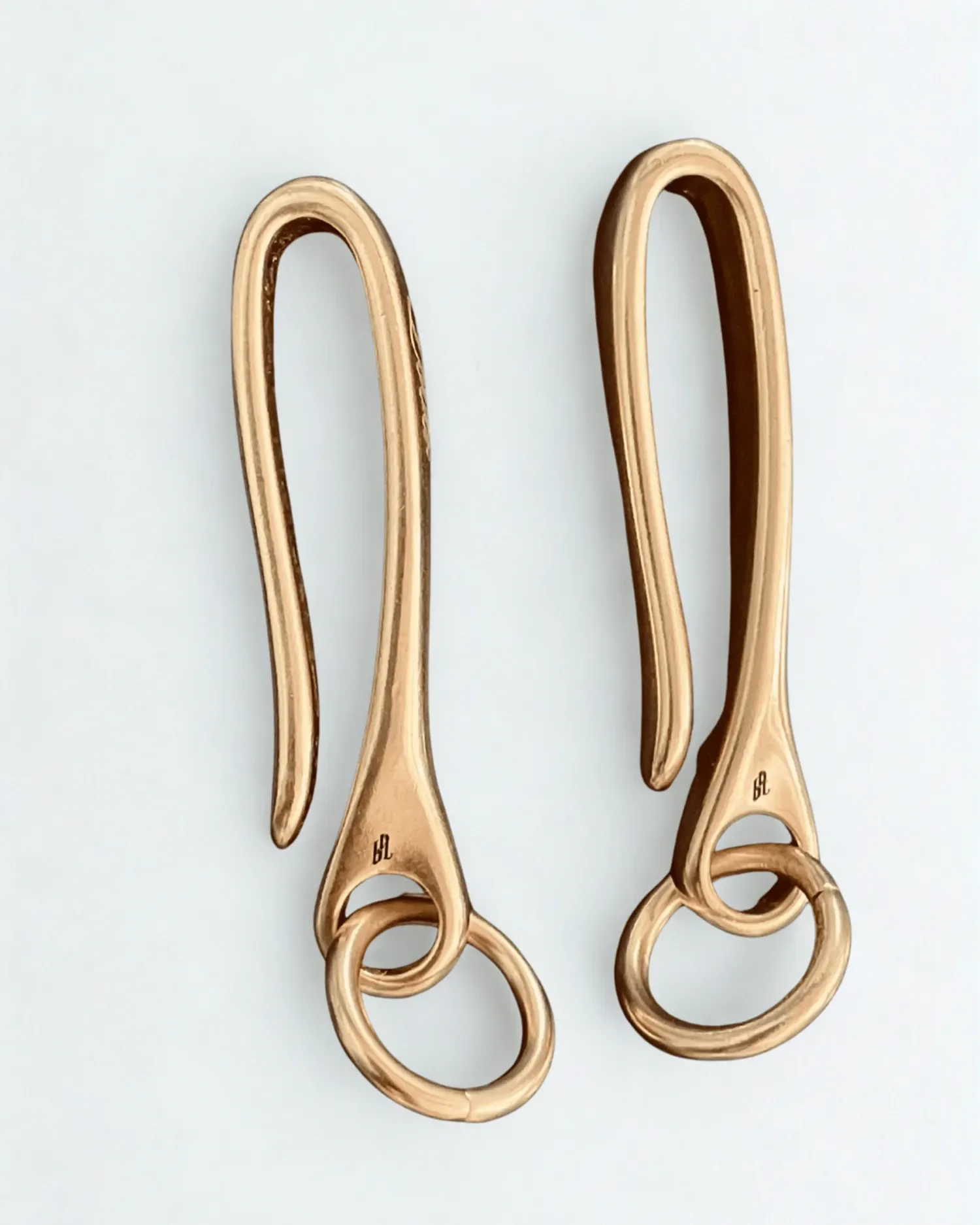 Close-up engraved brass fish hook keychain with Old English lettering side view