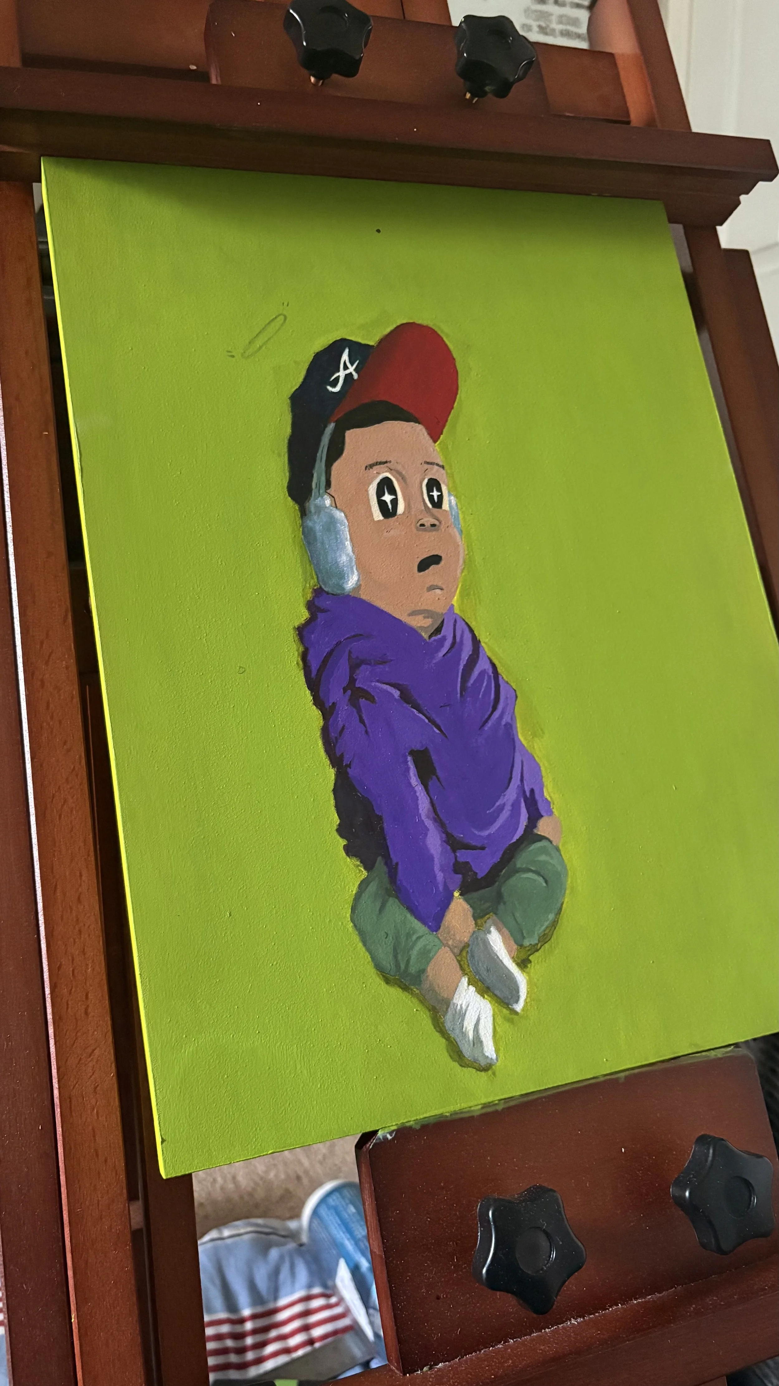 Colorful painting of a young boy sitting cross-legged, wearing a purple hoodie, green pants, white sneakers, a black and red cap, and listening to headphones, set against a bright green background.