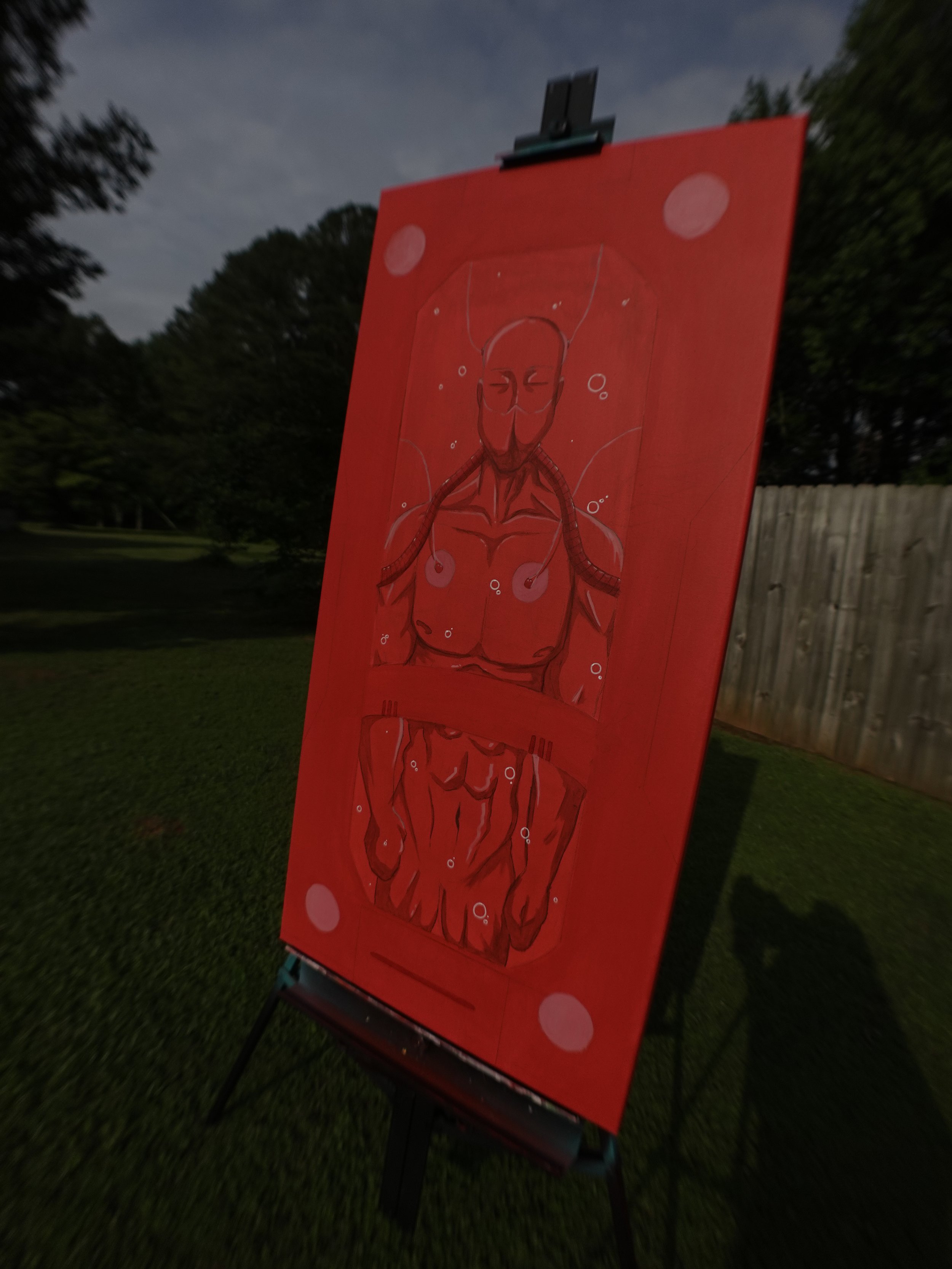 A red painting on an easel depicts a humanoid figure with an elongated head, closed eyes, and a serene expression. The figure is surrounded by abstract circular shapes and has visible musculature, with the painting set outdoors at dusk or nighttime.