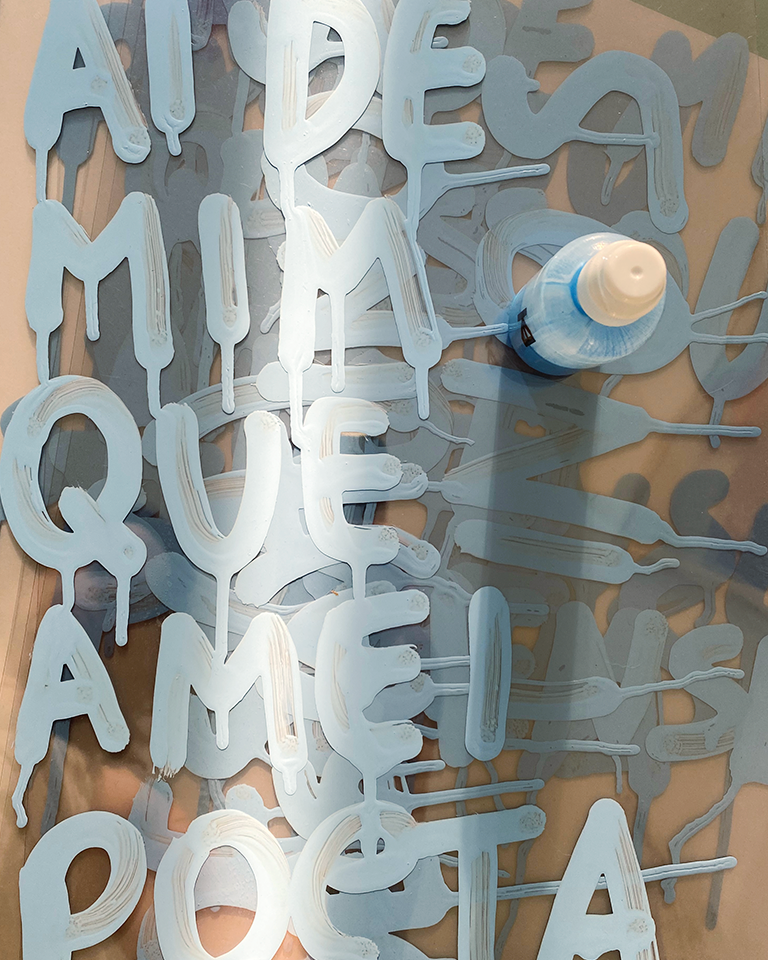 Letras escritas em papel acrílico transparente com tinta azul clara, sobrepostas entre elas.