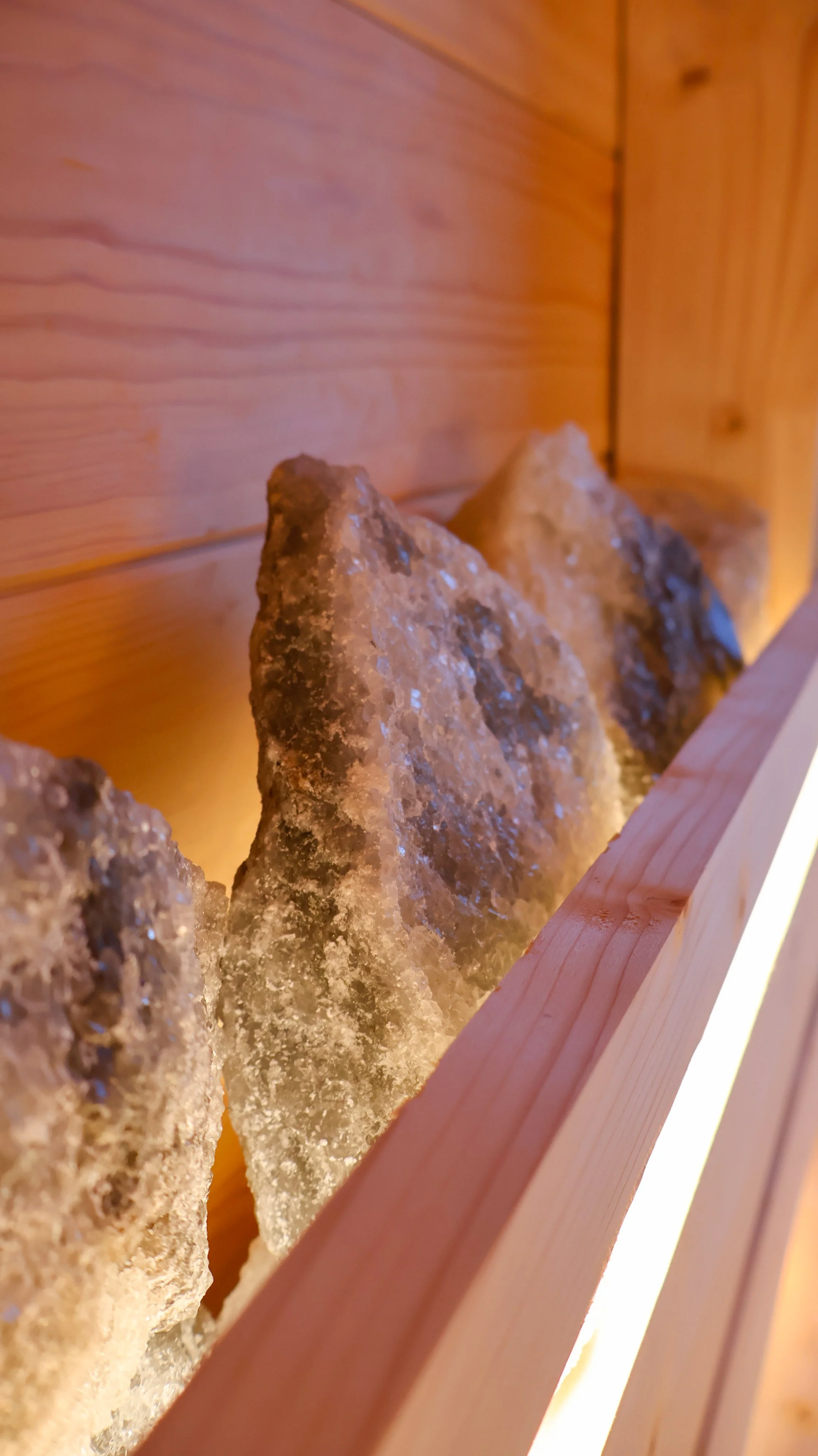 Close-up of large rocks inside a wooden frame with warm lighting.