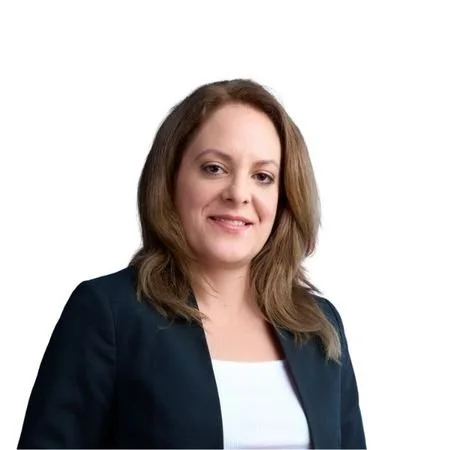 Woman with brown hair and black coat and white shirt