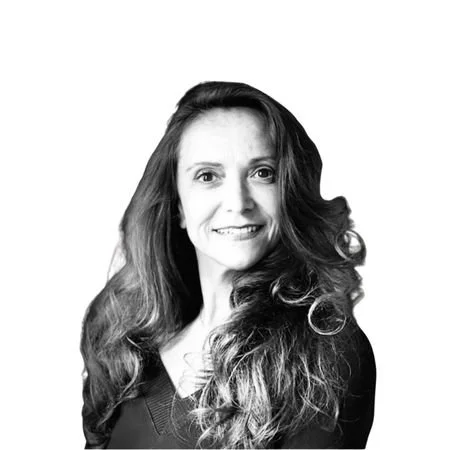 A woman with long hair, and a black shirt. Black and white image.