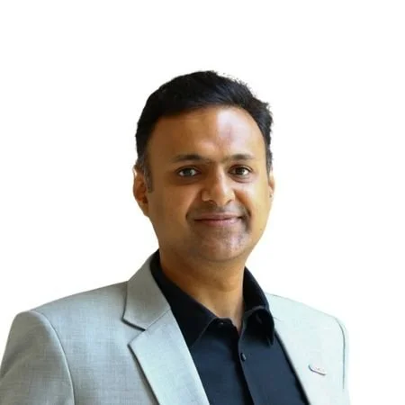 A man dressed in a white coat and a black shirt.
