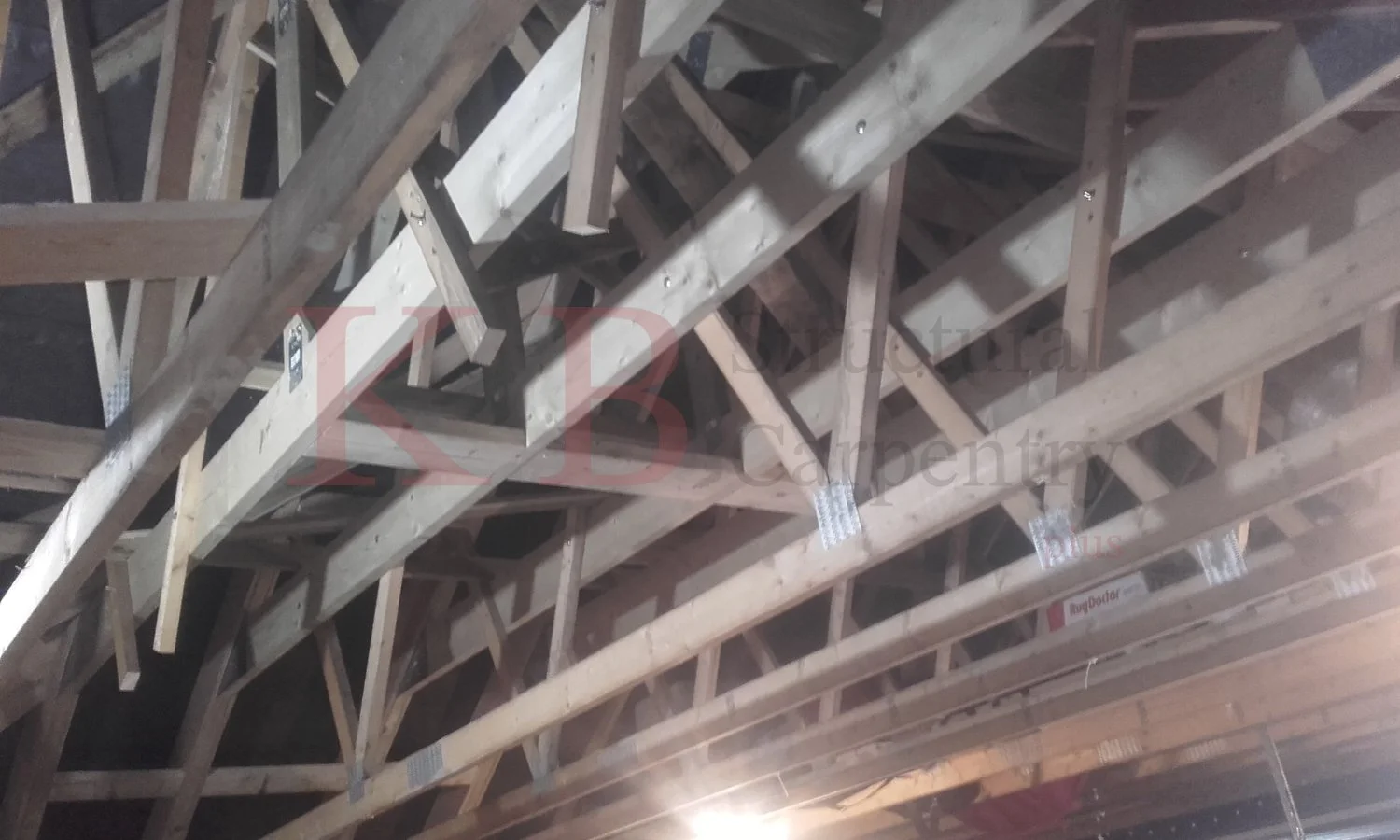 View of an unfinished wooden roof framework with wooden beams and supports.