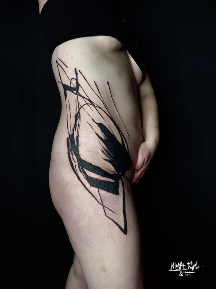 Abstract rib and hip tattoo