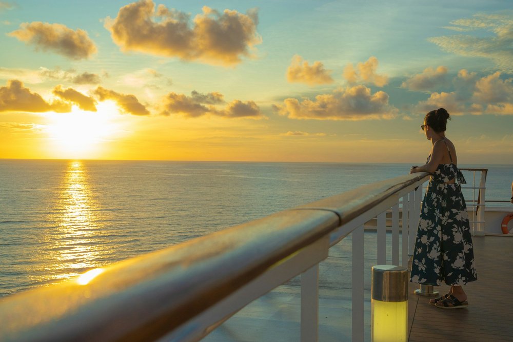 Traveler watching the sunset from the deck of a cruise ship