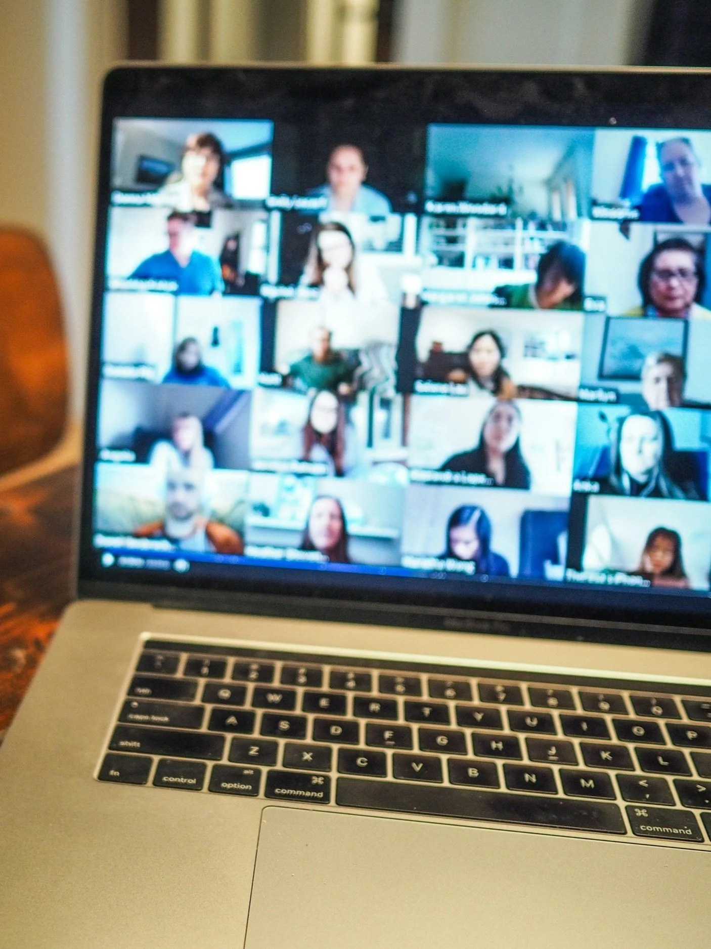 Laptop screen displaying a video conference with multiple participants.