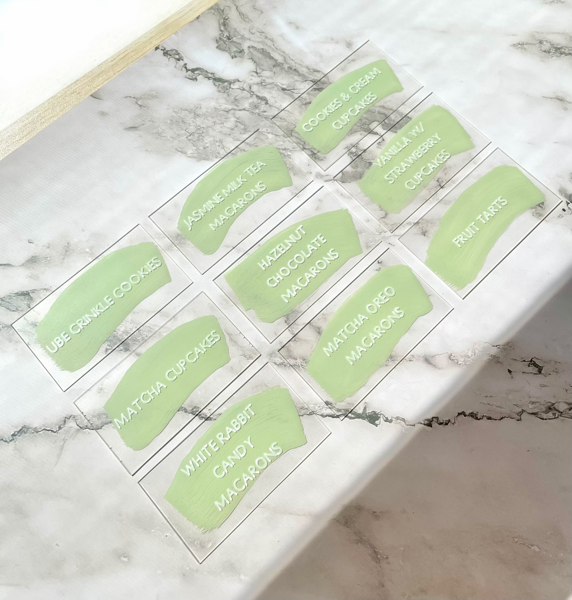Green swatches with handwritten dessert labels on a marble background