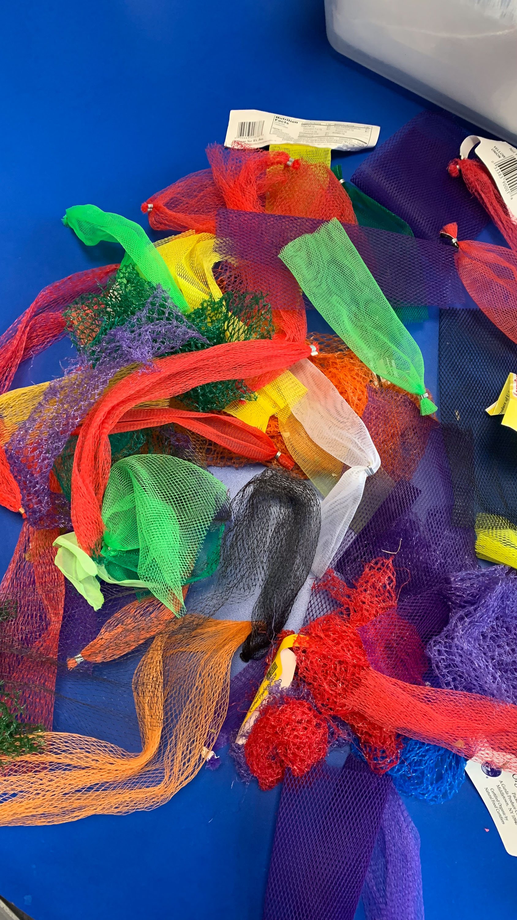 Colorful mesh ribbons and accessories scattered on a blue surface.