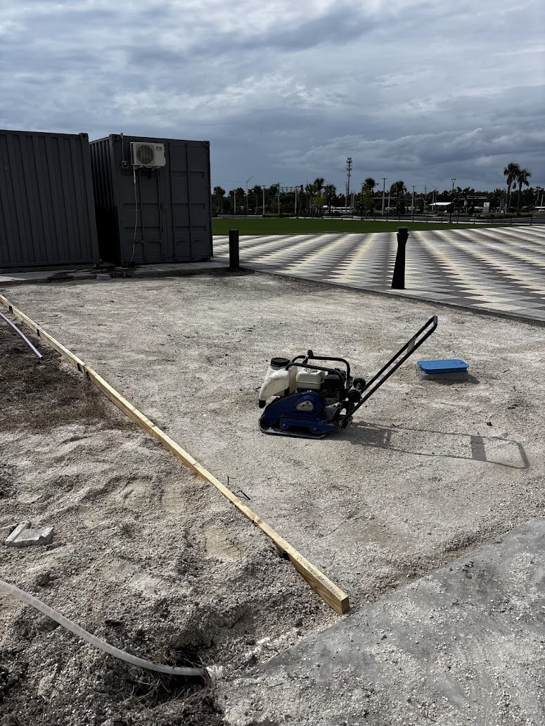 Site preparation and sand-base compaction for a custom checkerboard paver game court built by Abundance of Sunshine Inc. at a resort in the Sarasota–Bradenton area.