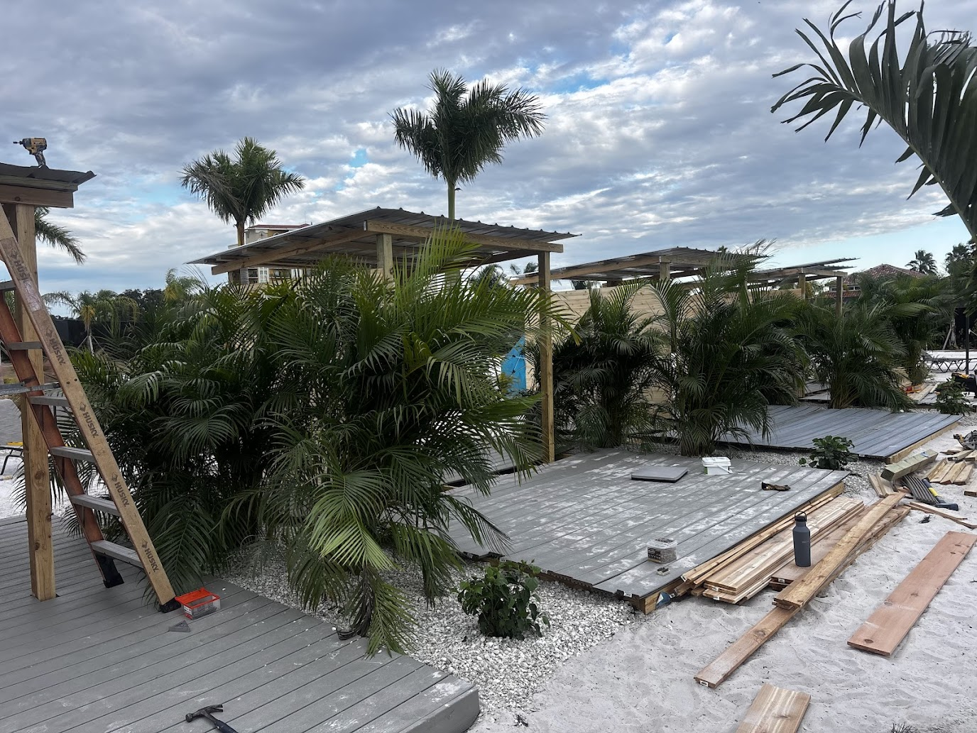 Beachfront property improvement by Abundance of Sunshine Inc. in the St. Petersburg–Clearwater area, including construction of adjacent patios and installation of tropical foliage to complement the custom cabanas and enhance the outdoor space.