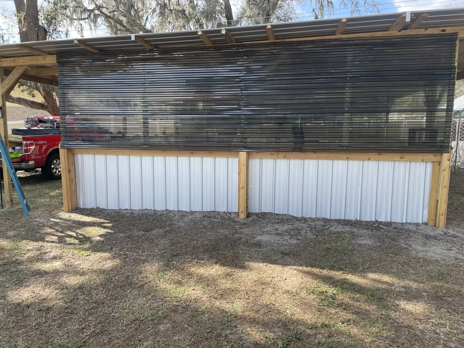 Custom lean-to pole barn designed and built by Abundance of Sunshine Inc. for a dog-training business in Lakeland, Florida, providing a covered and functional outdoor training area.