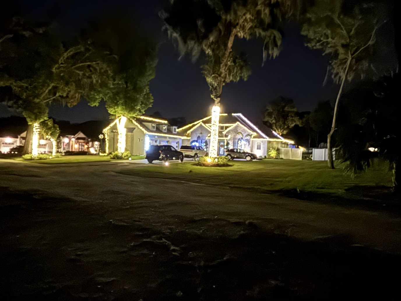 Large-scale Christmas lighting installation by Abundance of Sunshine Inc. at a Plant City, Florida property, featuring over a mile of lights around the home, palm trees, pool area and lanai.