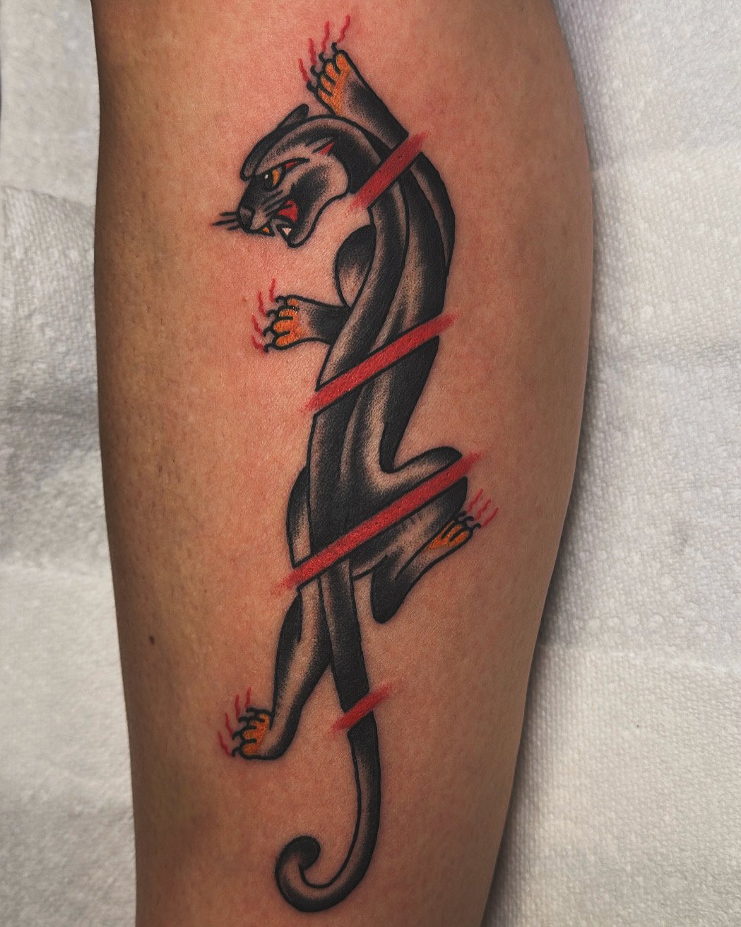 Panther tattoo design with red accents on skin