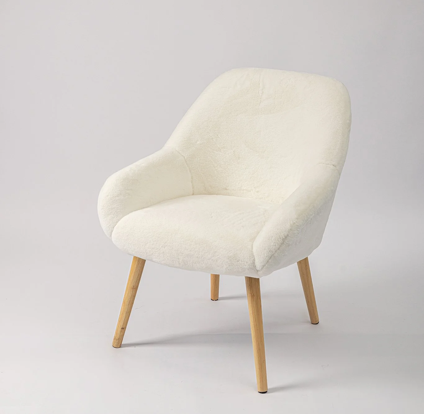 A modern Armchair with cream-colored upholstery and wooden tapered legs.