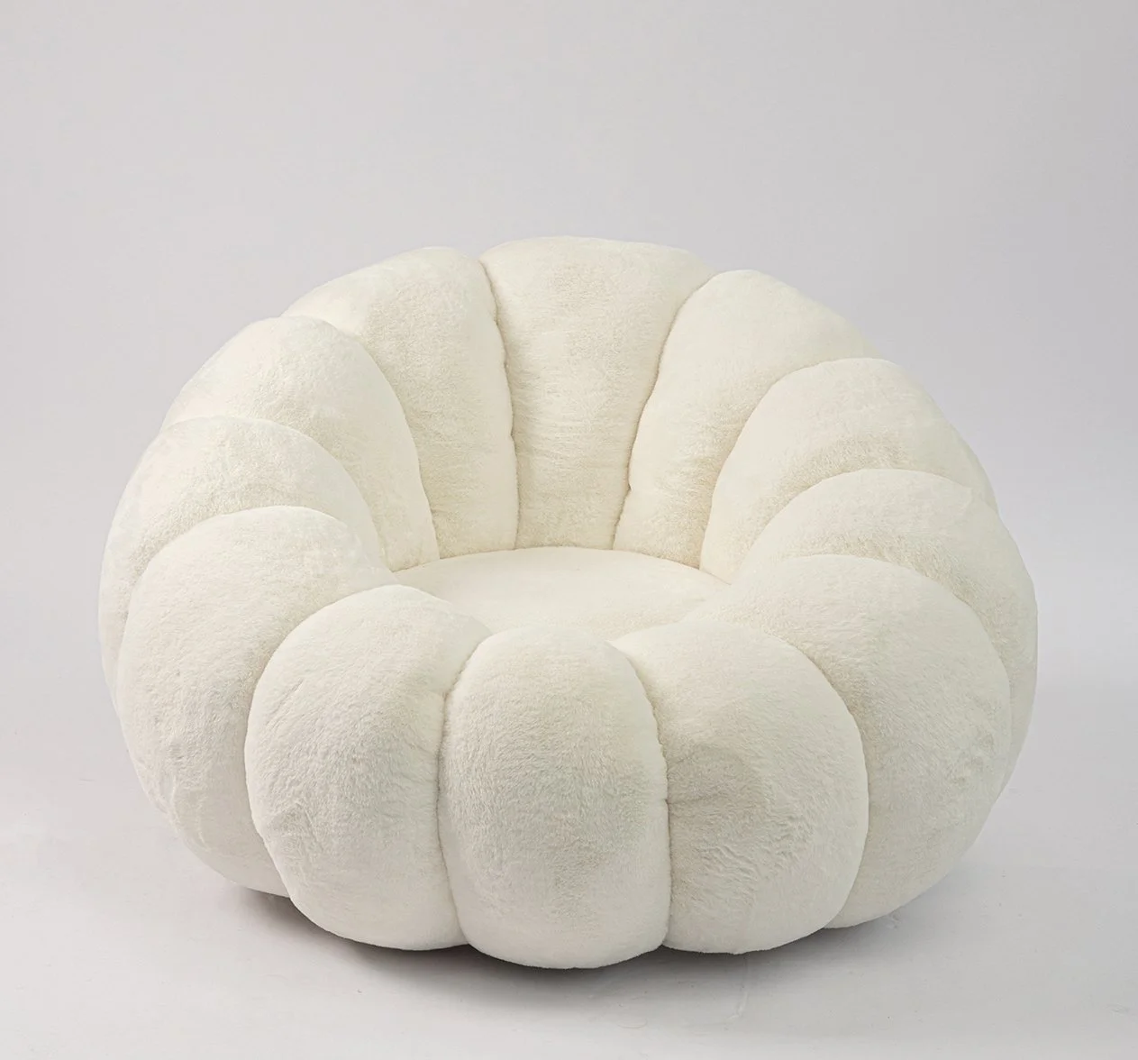 Round plush chair with a segmented, petal-like design in soft cream color against a light background.