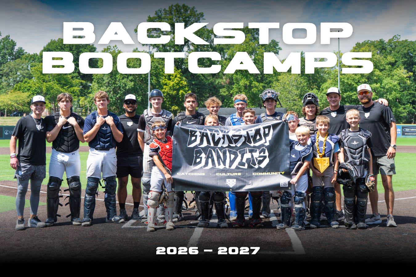 A group of smiling youth and high school catchers, and catching coaches, hold up the Backstop Bandits banner at the end of a summer Backstop Bootcamp