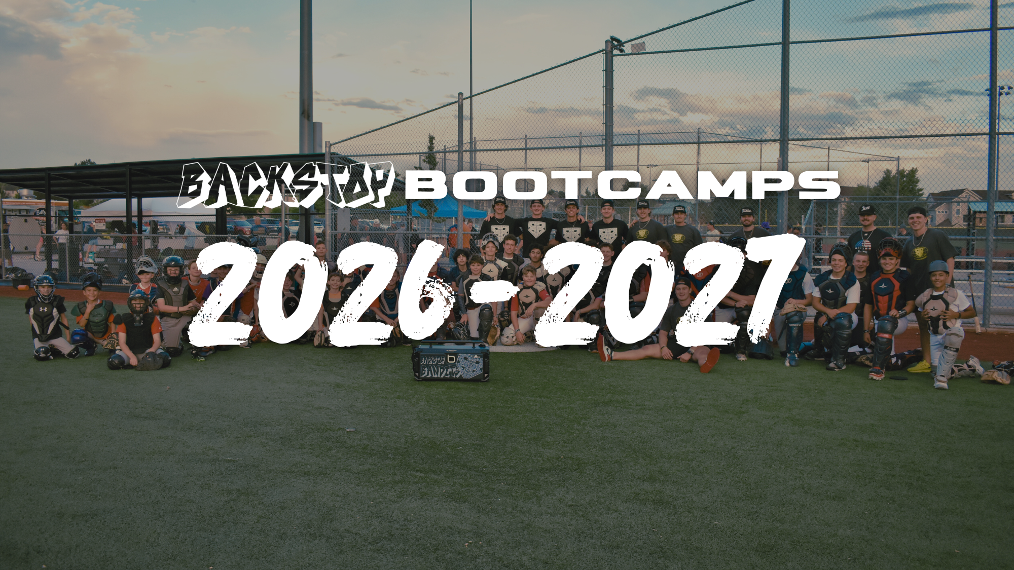 A large group of youth and high school catchers, and catching coaches smile on the last day of Backstop Bootcamp