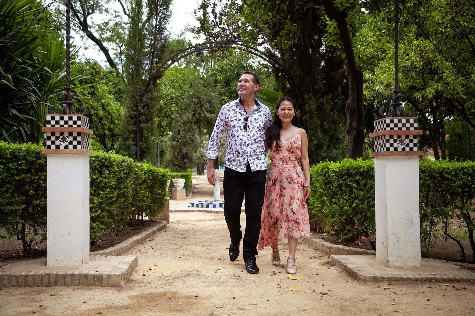A just engaged couple walking together in Seville's Santa Cruz old quarter.