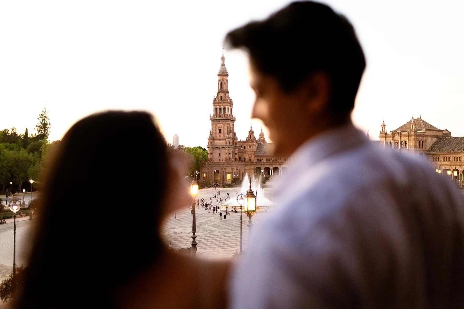 A couple slightly out of focus looking at each other at Seville's Plaza de España.