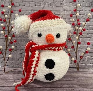 Handmade crochet snowman plushie with a cozy winter charm, perfect for holiday decor.