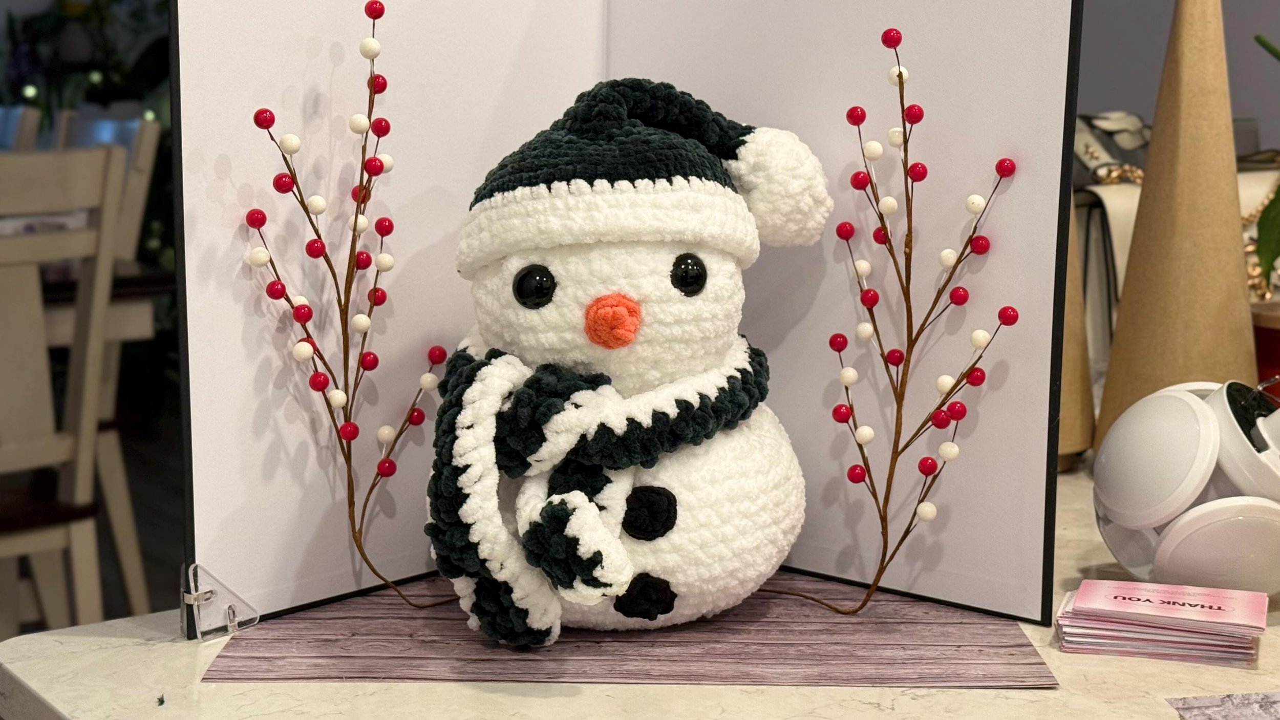 Handmade crochet snowman plushie with a cozy winter charm, perfect for holiday decor.