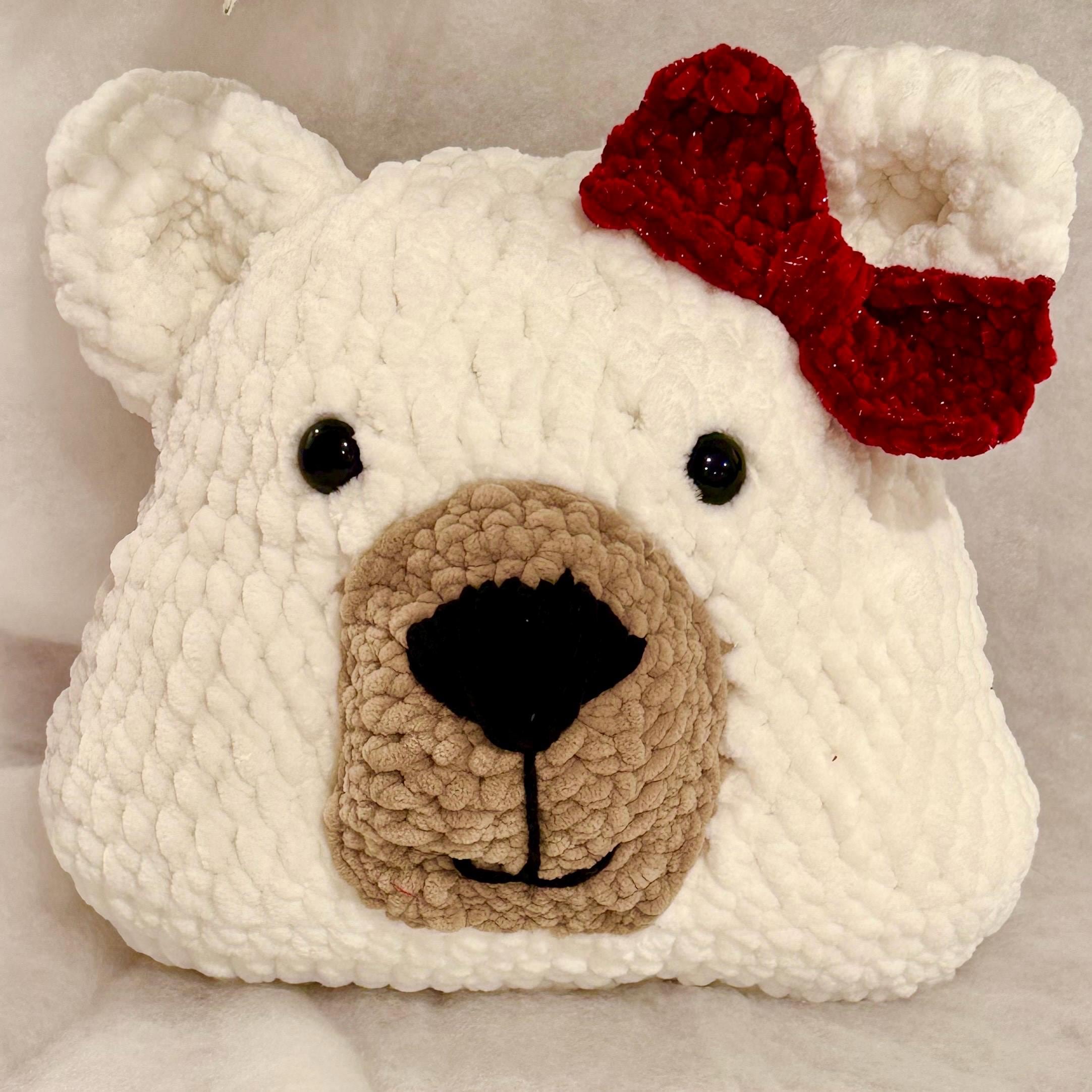 Soft and cuddly handmade crochet bear pillow with a bow, perfect for snuggling.