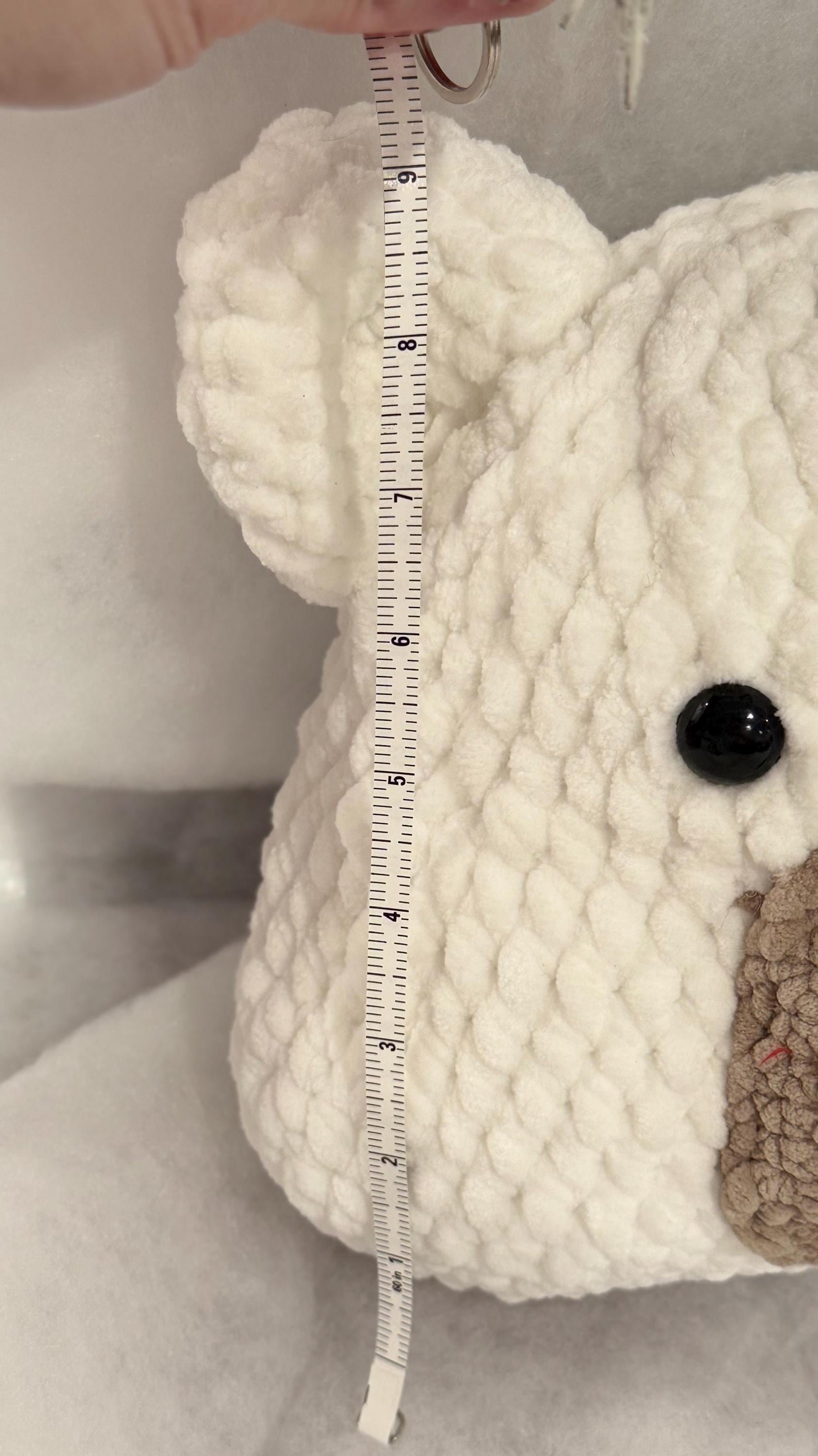 Soft and cuddly handmade crochet bear pillow with a bow, perfect for snuggling.