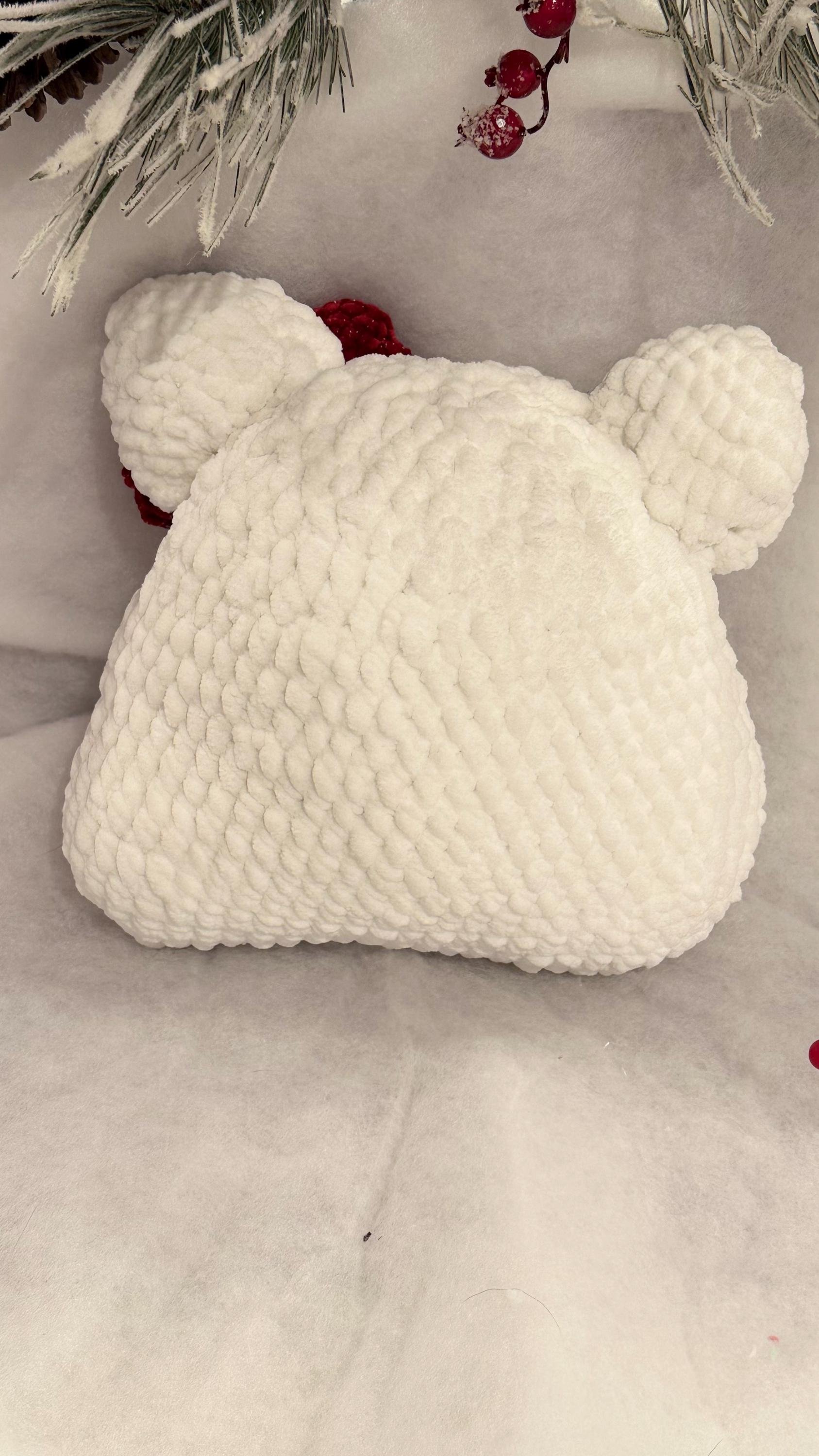 Soft and cuddly handmade crochet bear pillow with a bow, perfect for snuggling.
