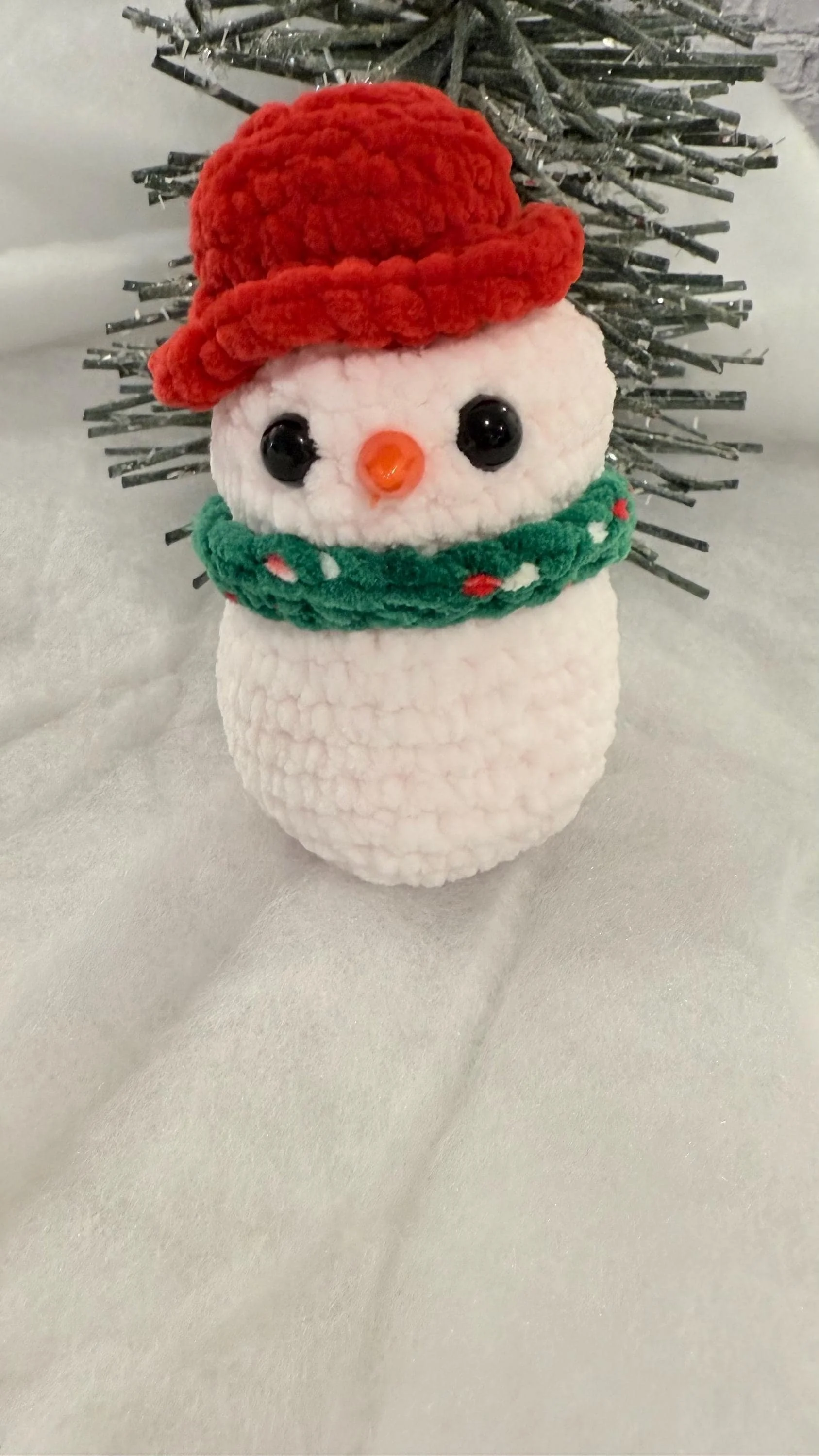 Adorable handmade crochet baby snowman plushie, a cute addition to holiday decor.