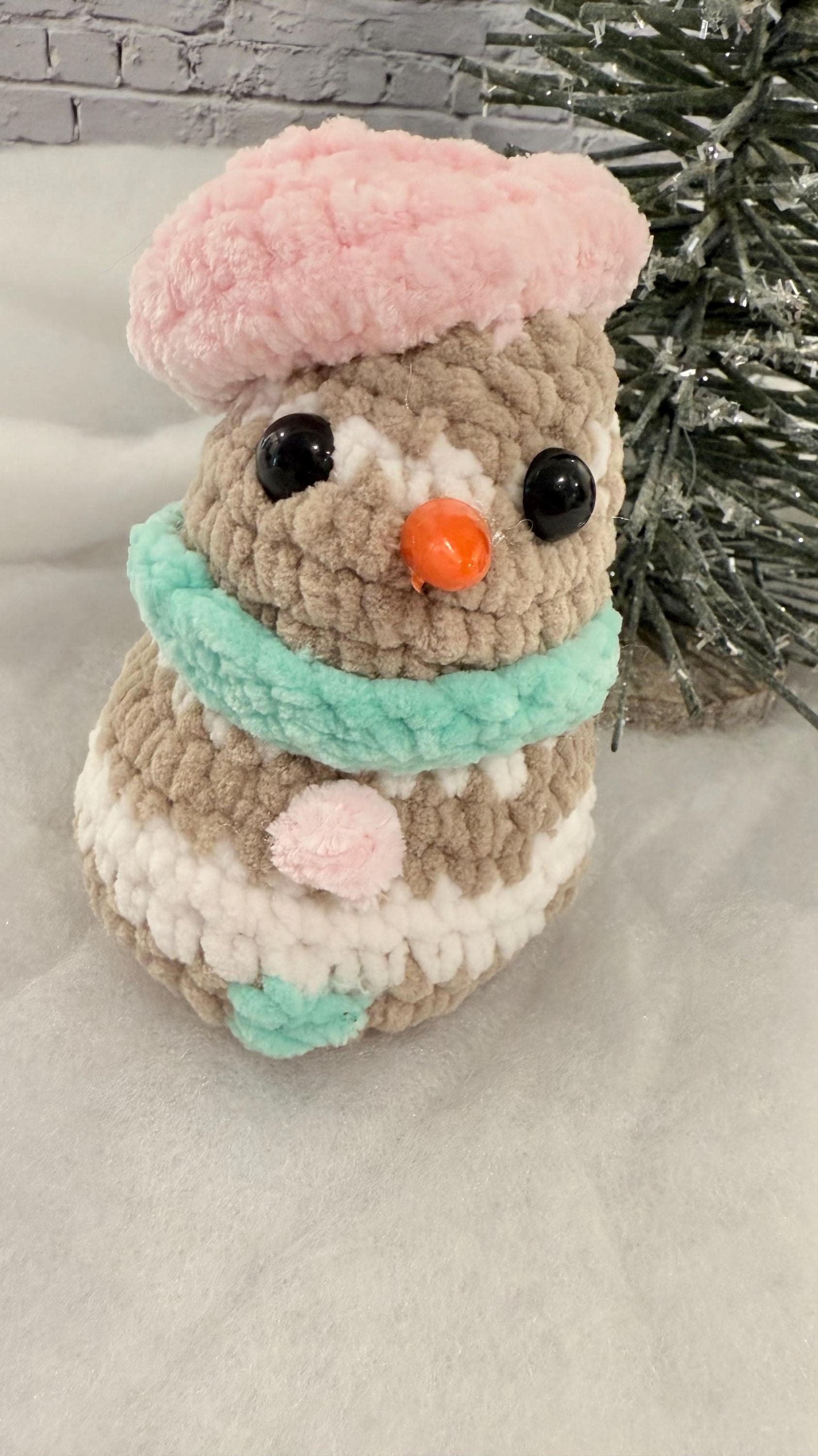 Adorable handmade crochet baby snowman plushie, a cute addition to holiday decor.