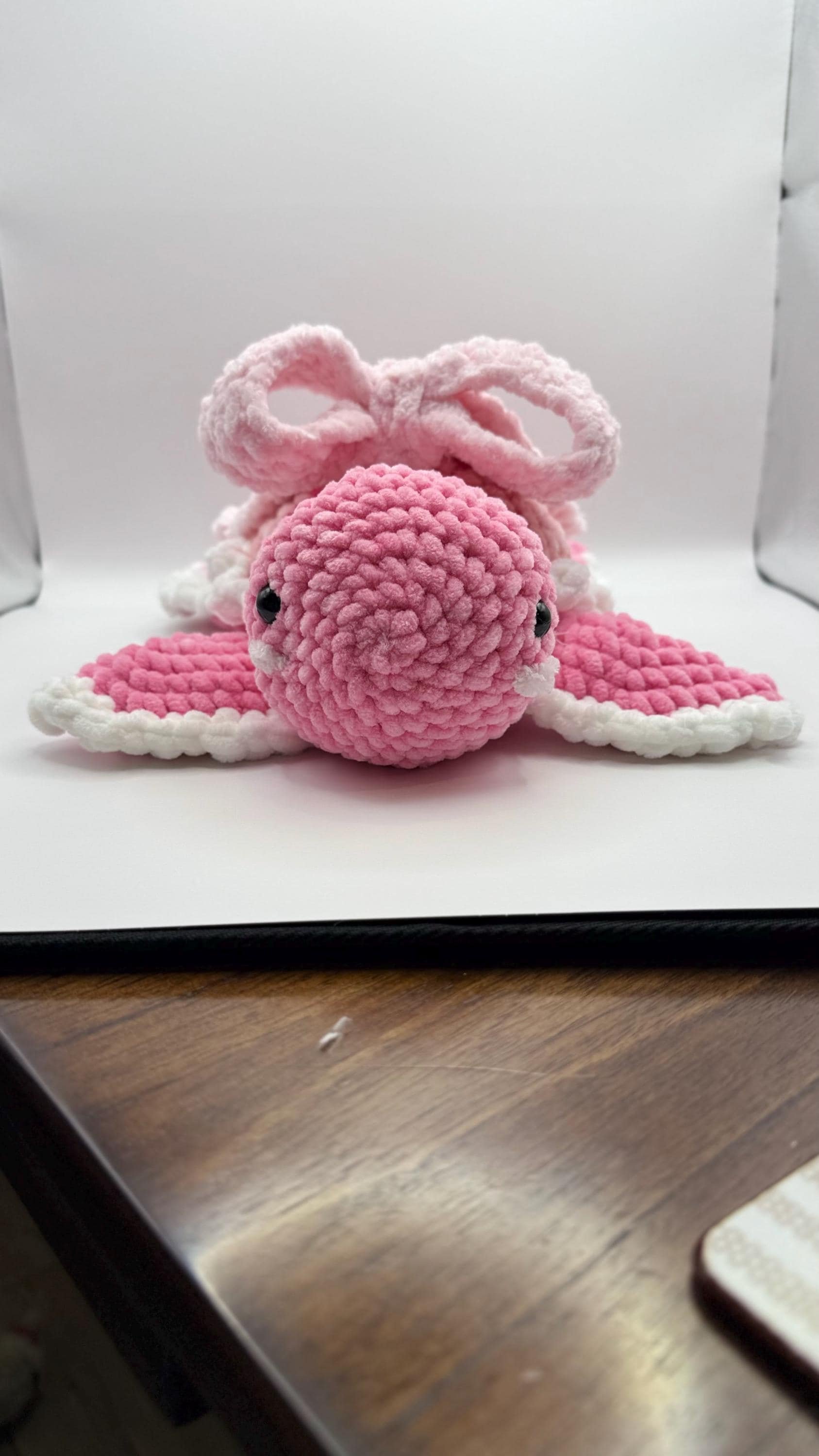 Adorable handmade crochet turtle plushie with a cute pink bow, perfect for gifts and decor.