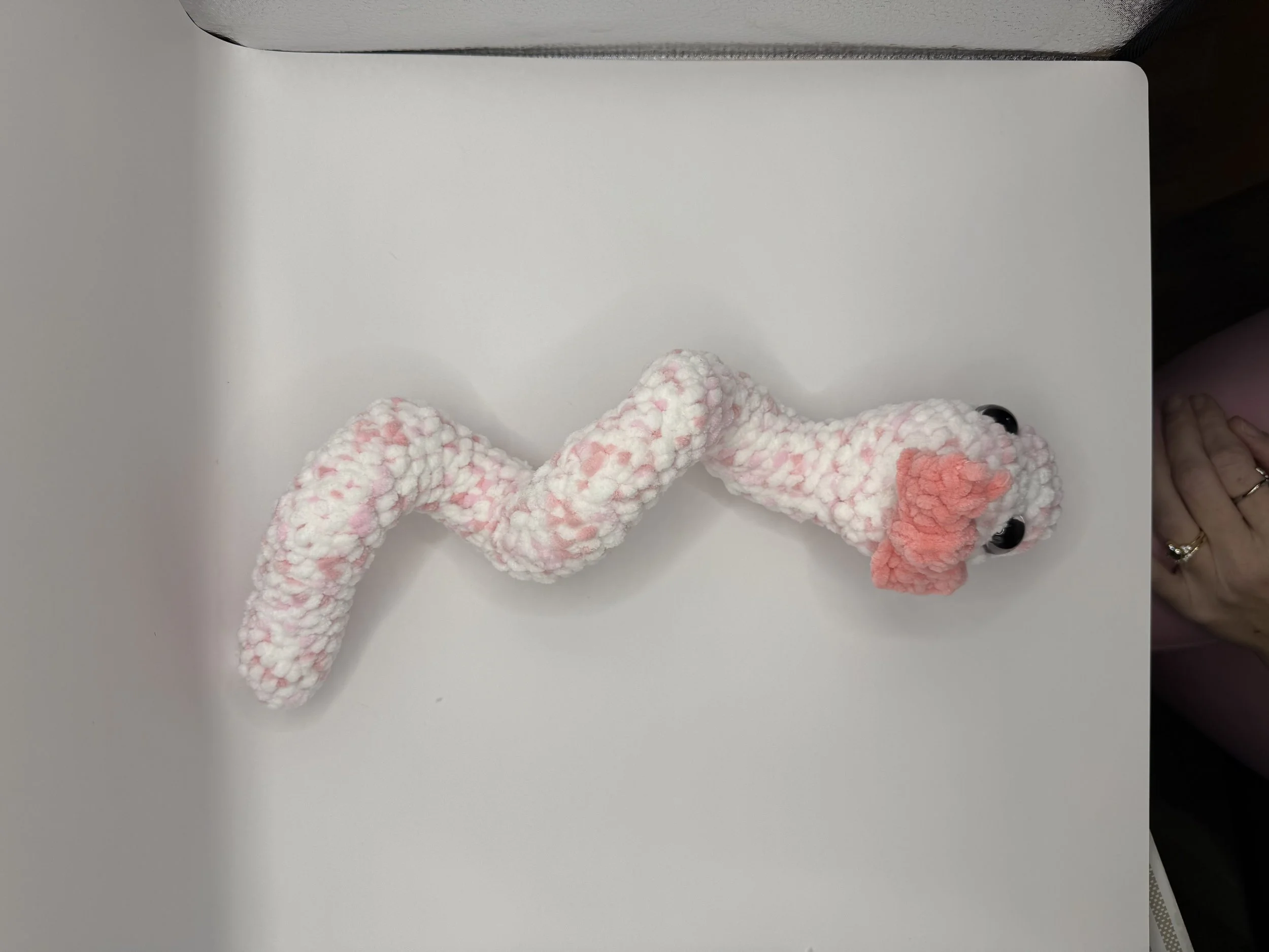 Handmade crochet snake plushie in vibrant multicolor design, a fun gift for reptile lovers.