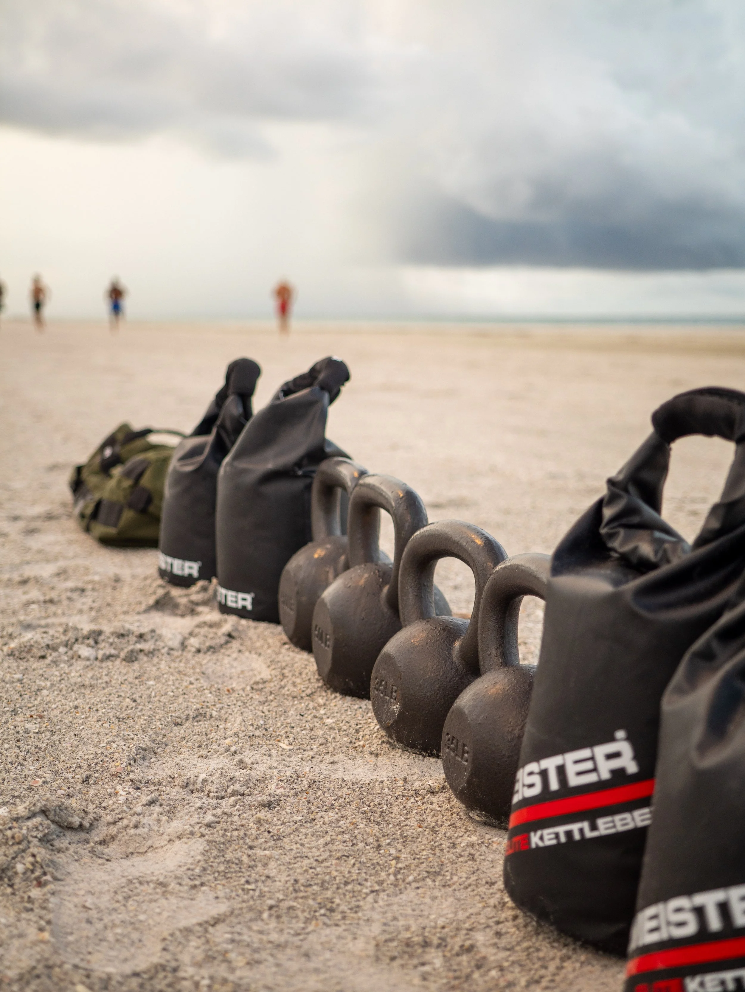 Functional fitness equipment arranged on the sand for a LUVSUM outdoor beach workout.