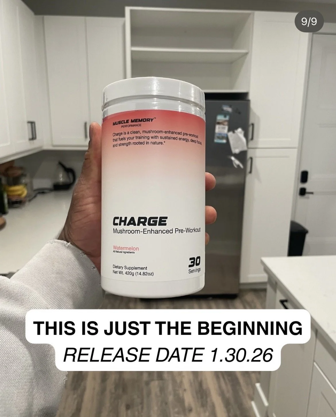 Hand holding a finished tub of CHARGE Watermelon pre-workout in a kitchen ahead of the January 30, 2026 launch