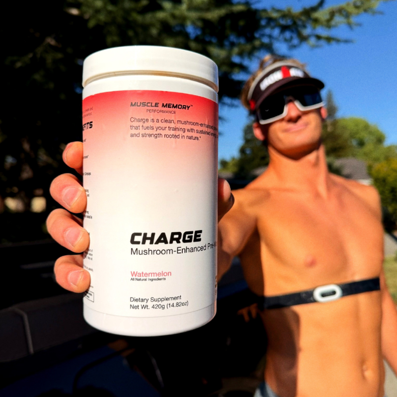 Athlete holding a bottle of CHARGE pre-workout outdoors before a training session