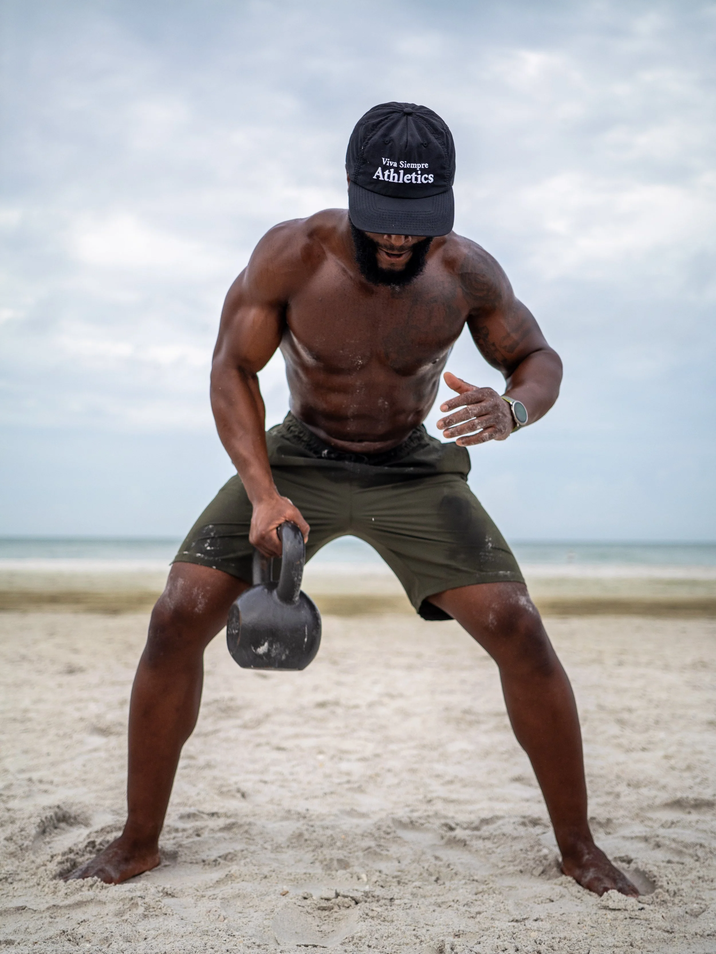 Muscle Memory Performance founder Ralph Patton III performing a functional strength workout on the beach.