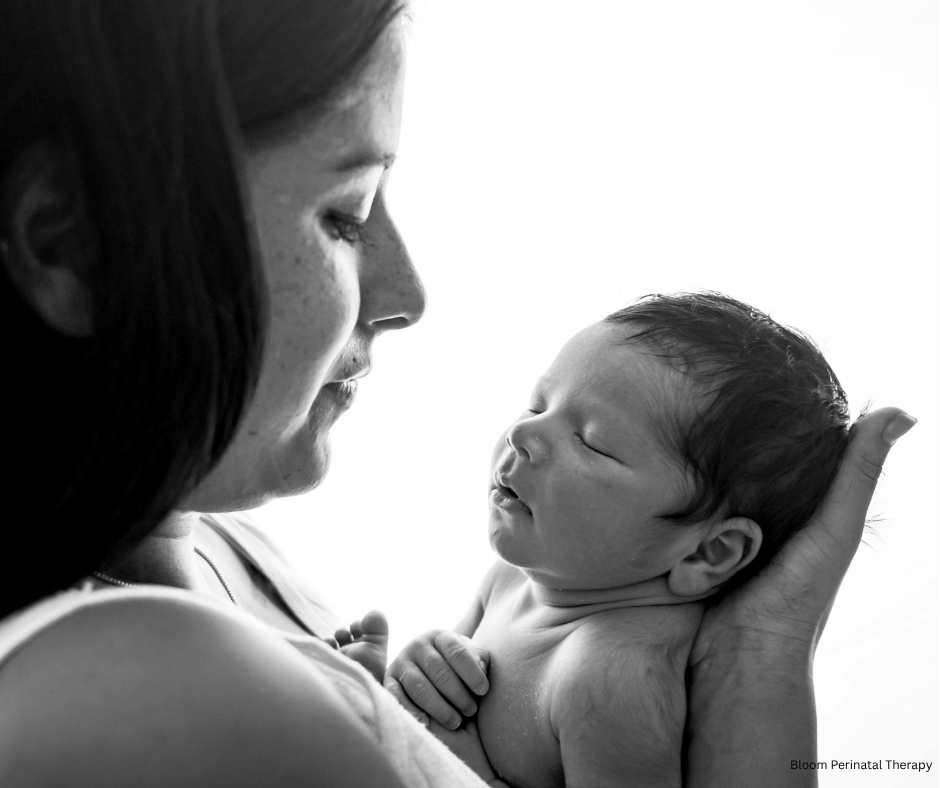 Mother holding newborn while reflecting on difficult birth experience