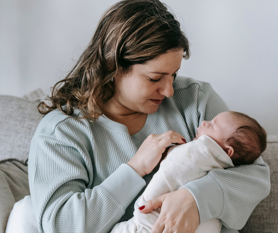 New mother bonding with her newborn while adjusting to postpartum recovery.