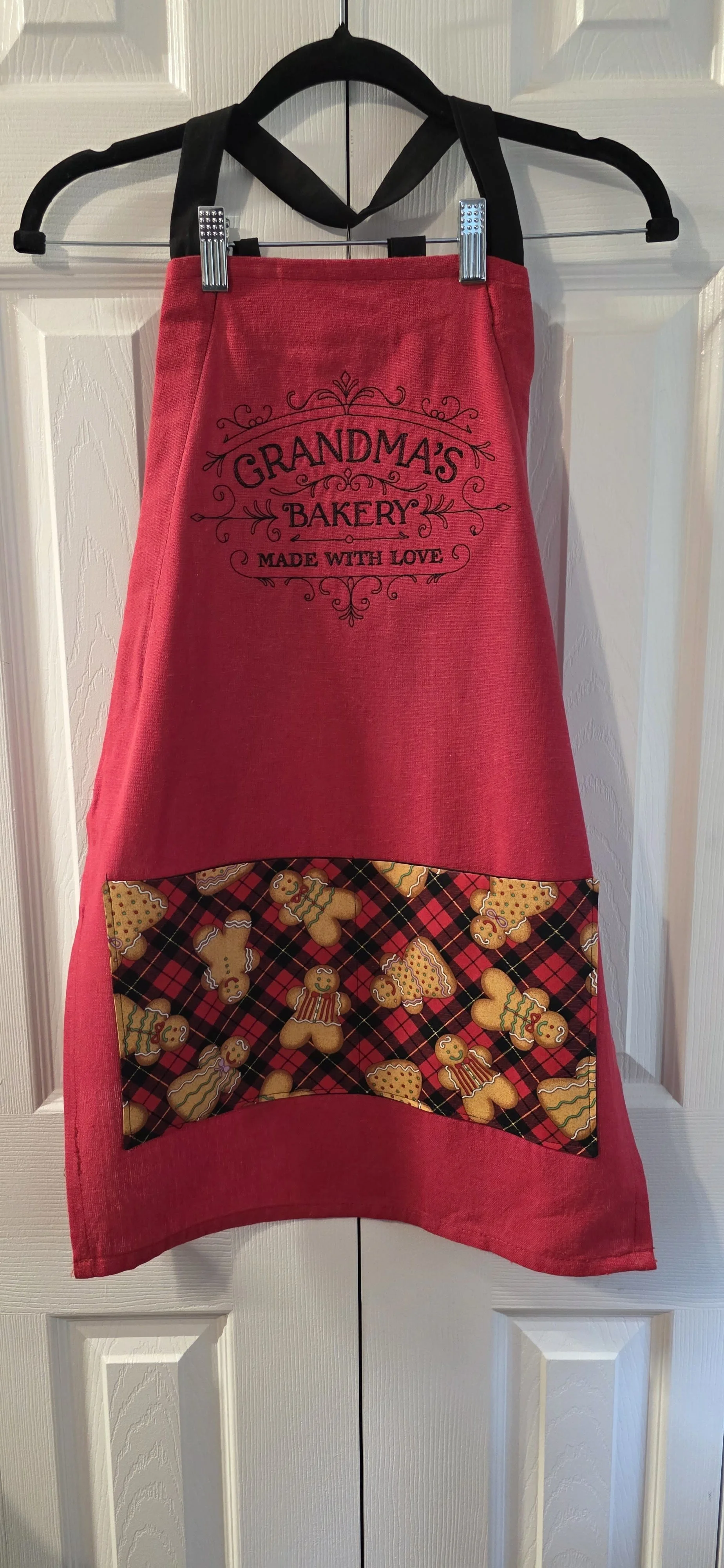 Adjustable tea towel apron. Embroidered with Grandma's Bakery with gingerbread cookie pocket.