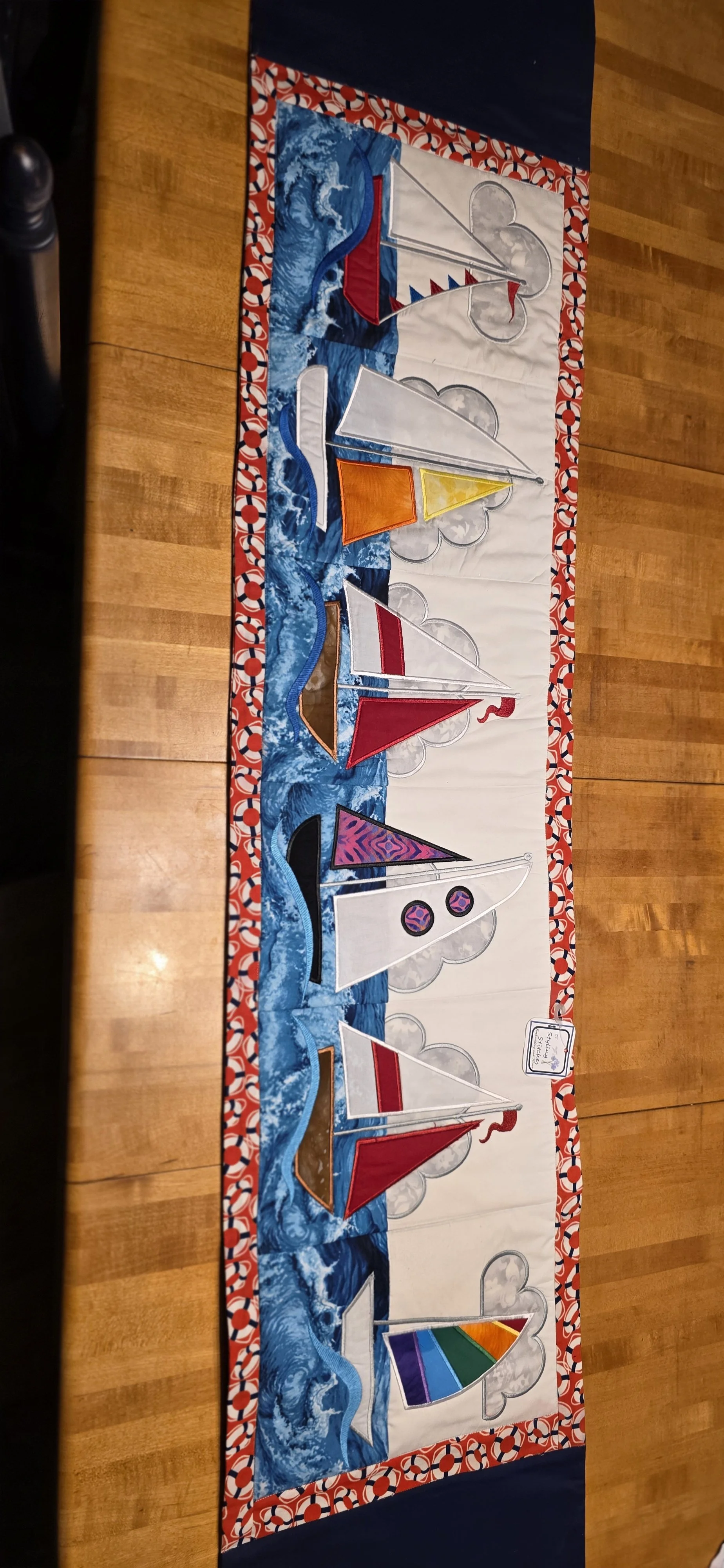 Embroidered 6 Sailboat panels table runner with life savor boarder and backing. 13x58