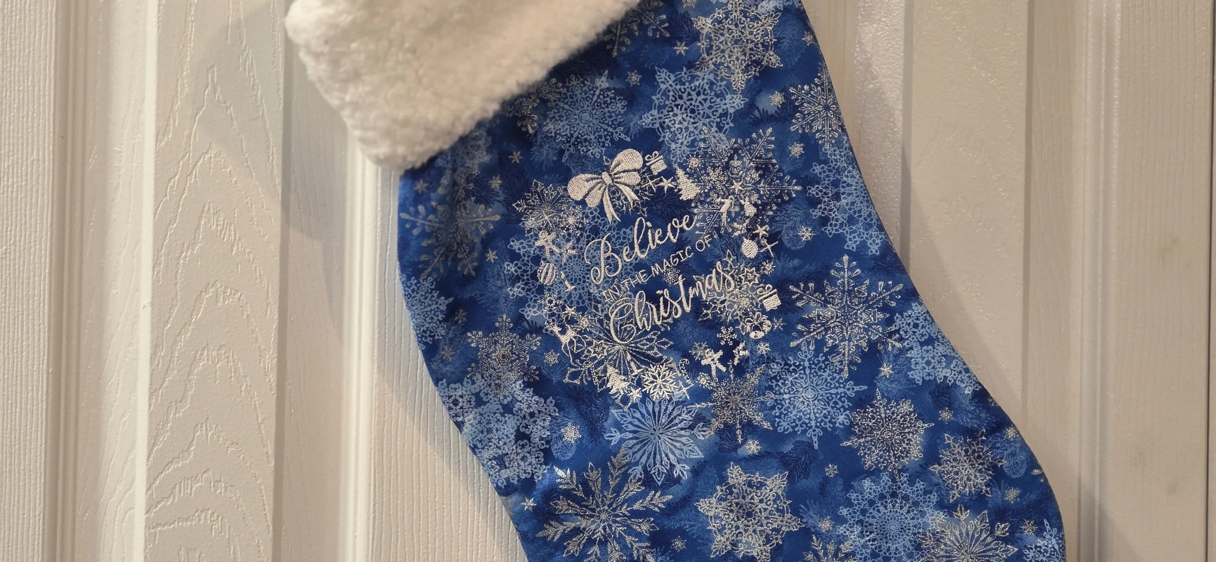 Blue embroidered Christmas belive in the magic of christmas stocking.