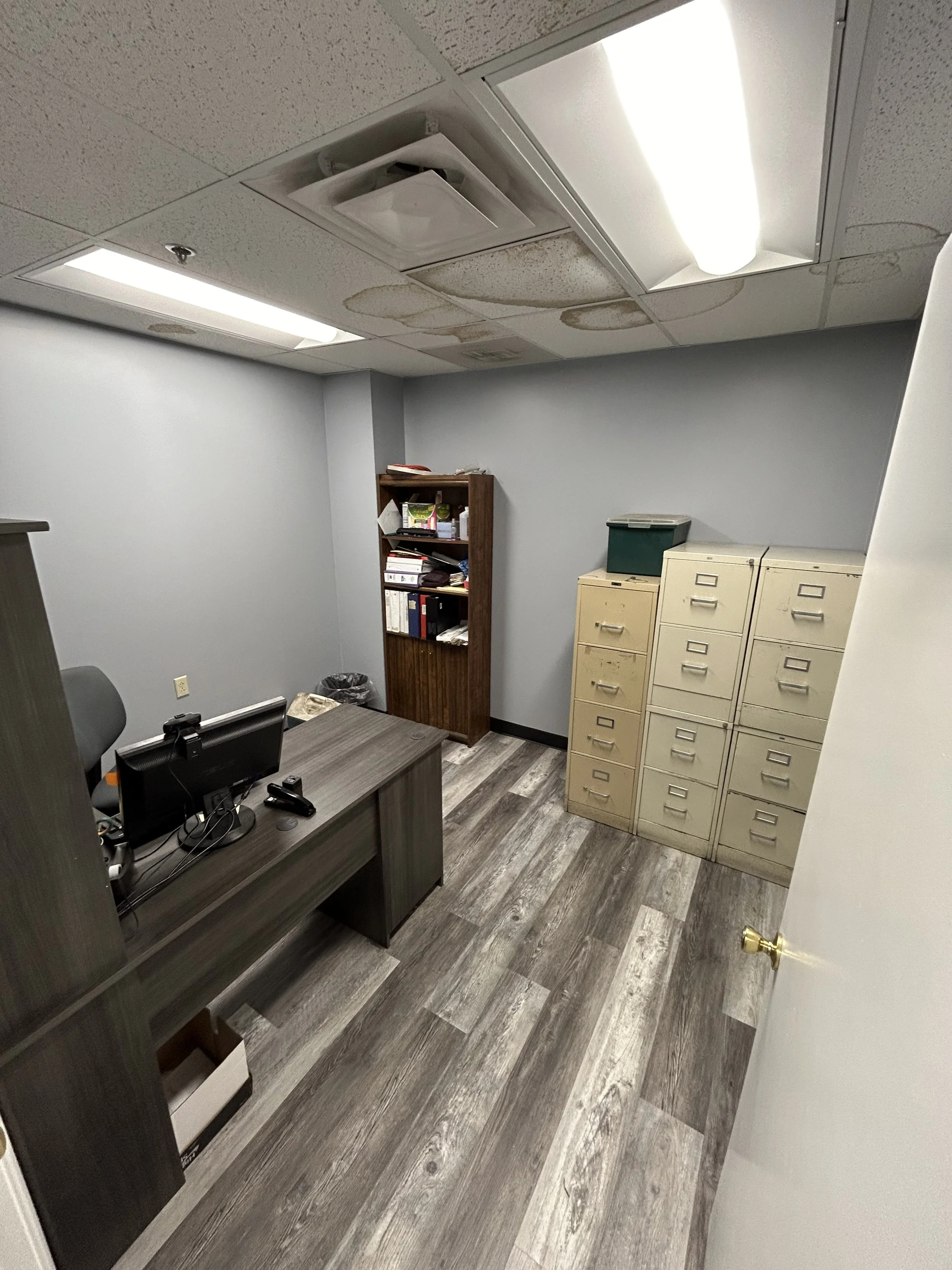 Updated business workspace featuring desks, storage cabinets, shelving, and modern flooring