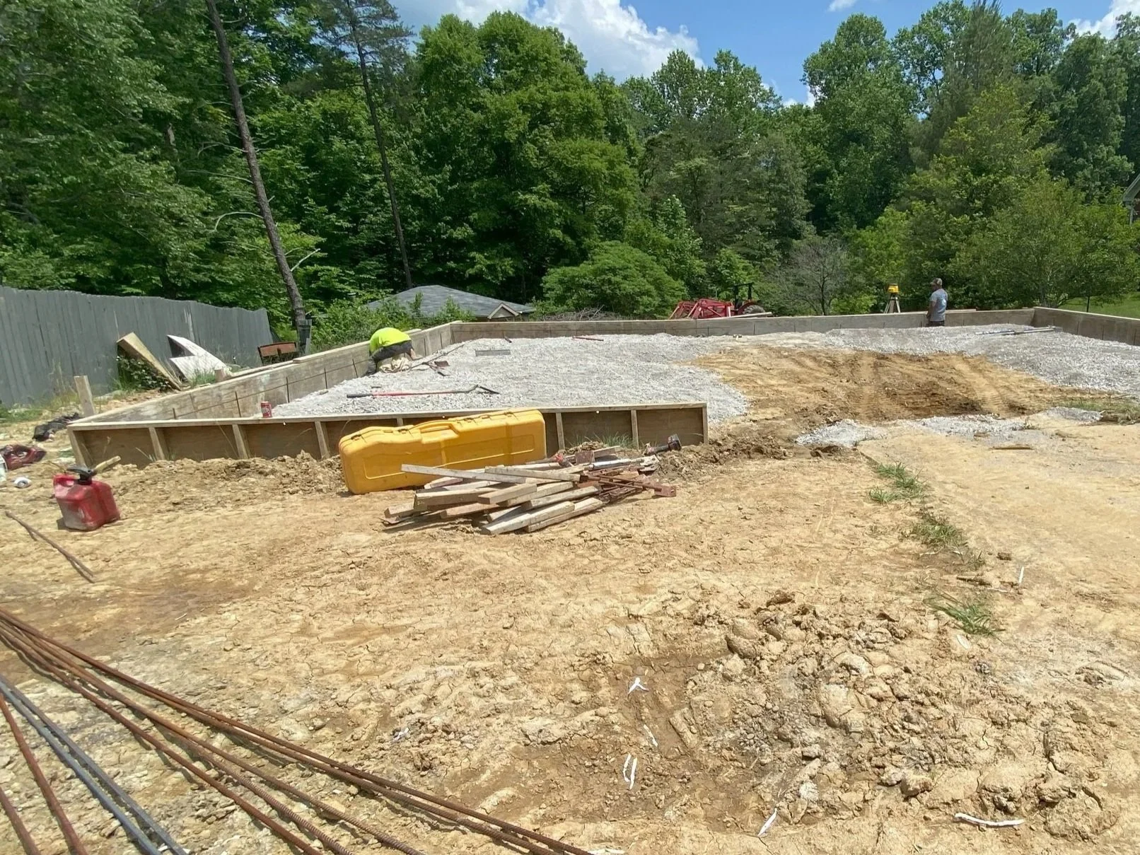 Open construction site showing leveled ground, concrete forms, and materials staged for a commercial expansion