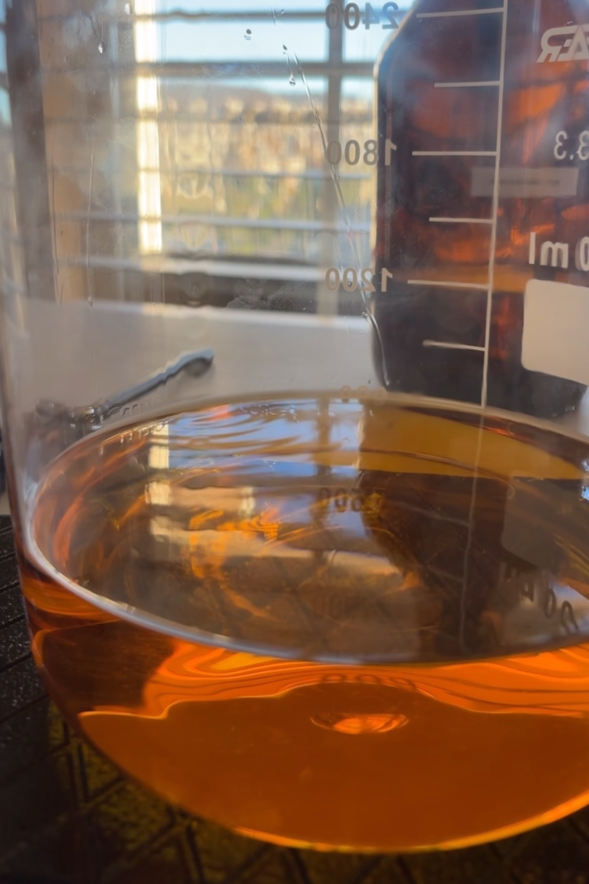 Clear beaker filled with nontoxic golden amber perfume. Nontoxic floral perfume, nontoxic gourmand perfume.