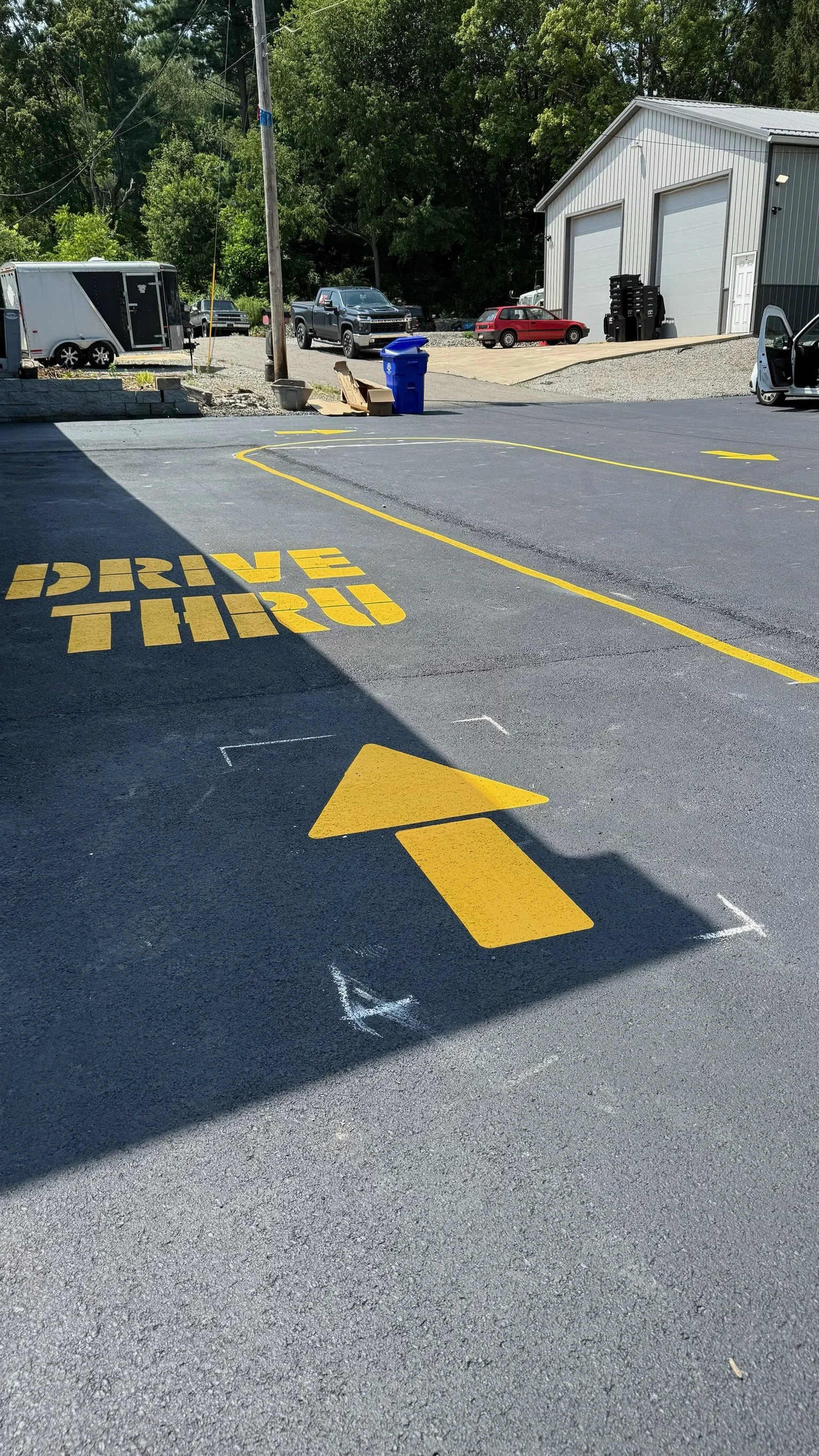 Parking lot with yellow painted words 'DRIVE THRU' and directional arrow on the asphalt